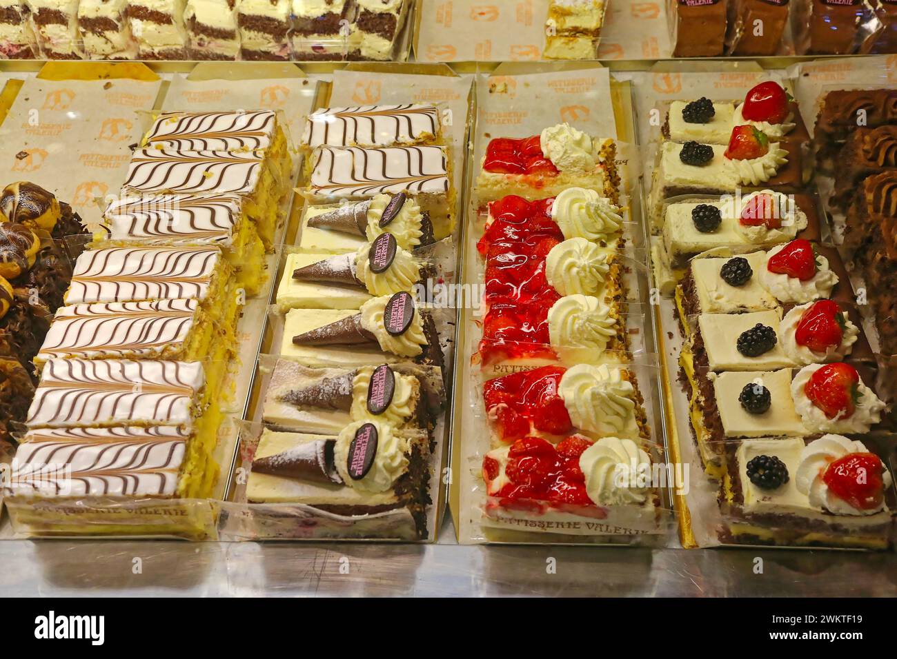 London, Vereinigtes Königreich - 24. November 2013: Fancy Cakes mit Erdbeeren und Schokolade im Vitrinen-Kühlschrank in der Patisserie Valerie. Stockfoto