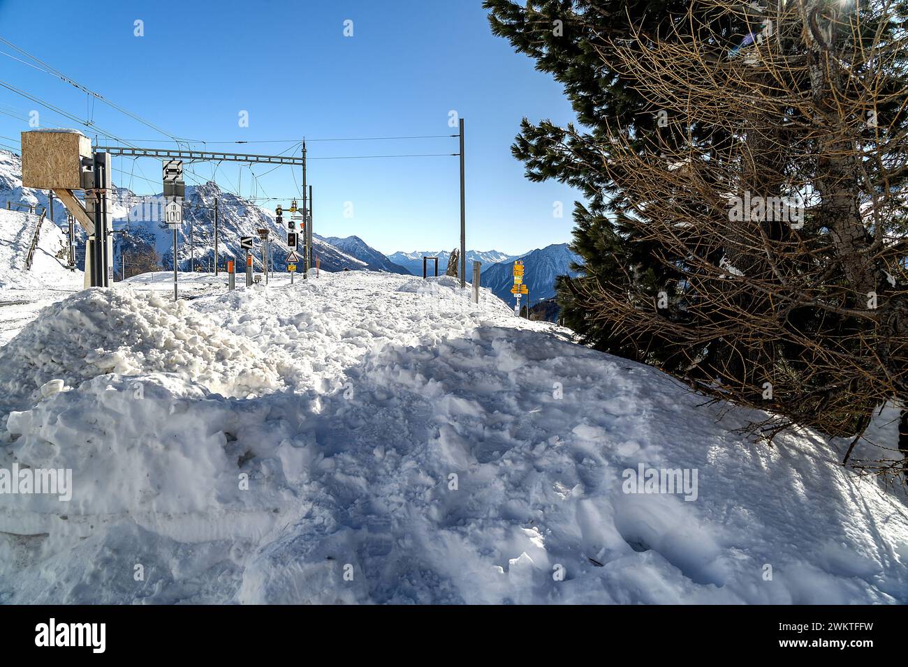 Eine Bernina-Bahnhaltestelle auf der Alp Grum in den Schweizer Alpen. Im vorderen Schneehaufen Stockfoto