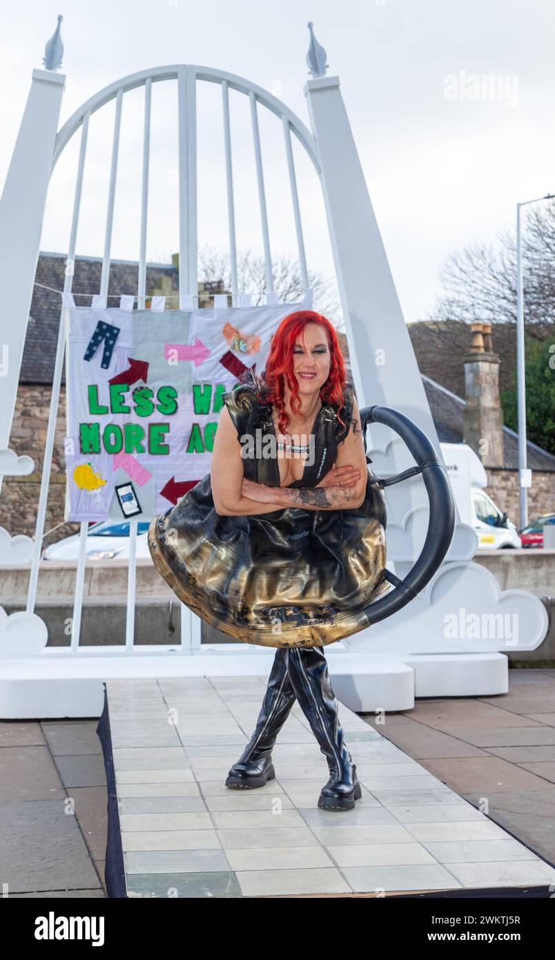 Edinburgh, Schottland. 22. Februar 2024. Ein Modell in einem Kleid aus recycelten Reifen strebt auf einem Laufsteg vor dem schottischen Parlament, um das Bewusstsein für unseren verschwenderischen und umweltbelastenden Materialverbrauch zu schärfen. © Richard Newton / Alamy Live News Stockfoto