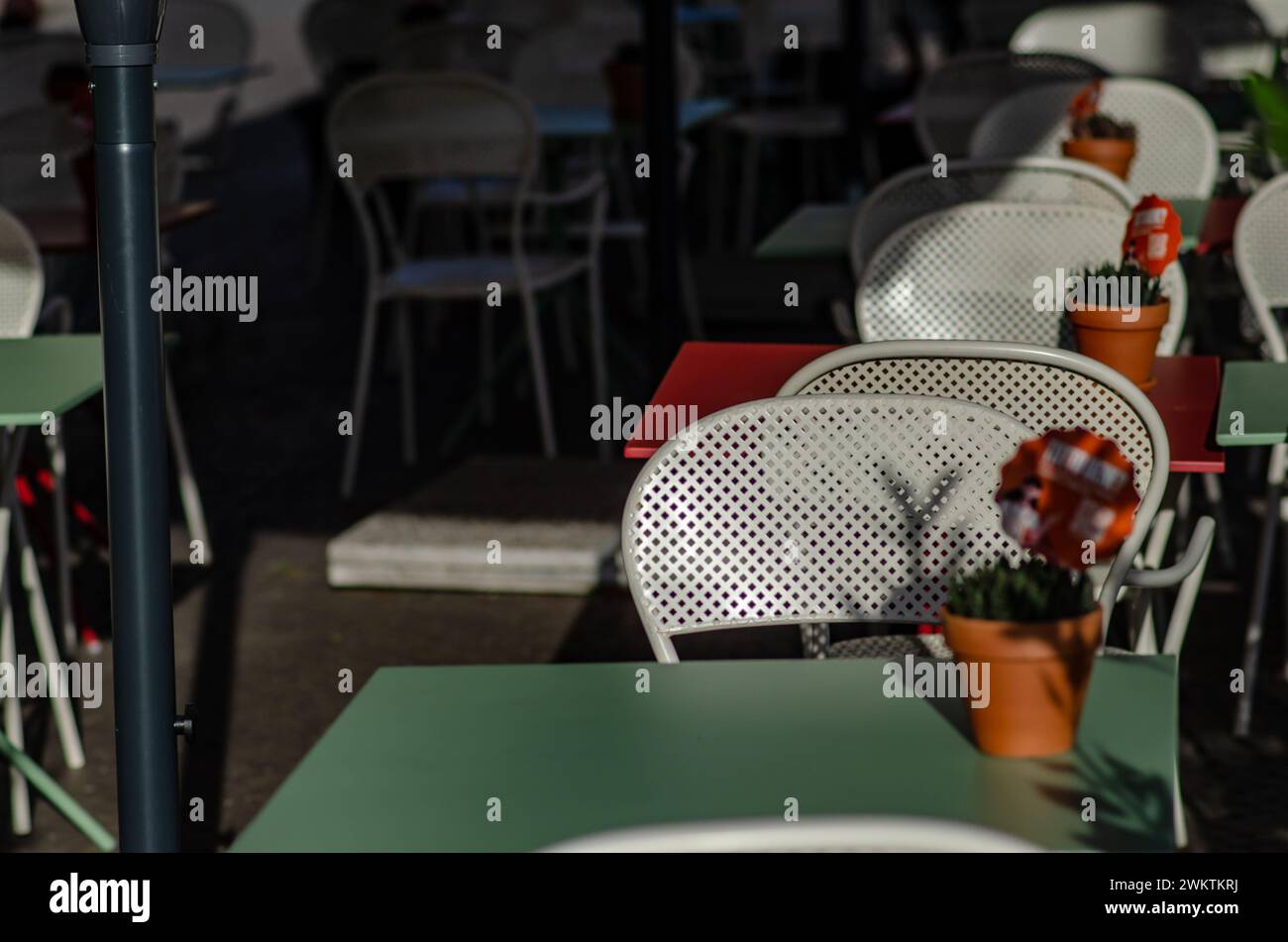 Tische eines Restaurants im Freien auf dem Platz eines Touristenorts, ein weißer Tisch und Stühle, an Feiertagen lieben Touristen, im Sommer draußen zu essen Stockfoto