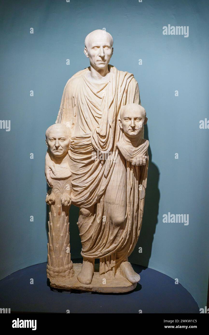 Toga-tragende Statue, bekannt als die „Barberini Toga tragende Statue“ aus der Barberini-Sammlung, 10-1 v. Chr., Pentelistischer Marmor - diese berühmte Statue zeigt einen Mann mit einer Tunika und Toga, der zwei Köpfe hält - Bildnisse verstorbener Verwandter. Ausgehend von den Eigenschaften der beiden Porträts wird angenommen, dass die Büste links die Vaterfigur und die rechts den Großvater darstellt. Das alte Haupt der Statue ist nicht das Original. Diese Grabstatue zeugt bildhaft von einer alten römischen Tradition, durch die aristokratische Familien die Erinnerung an die Gesichtsfigur ihres Vorfahren bewahren würden Stockfoto