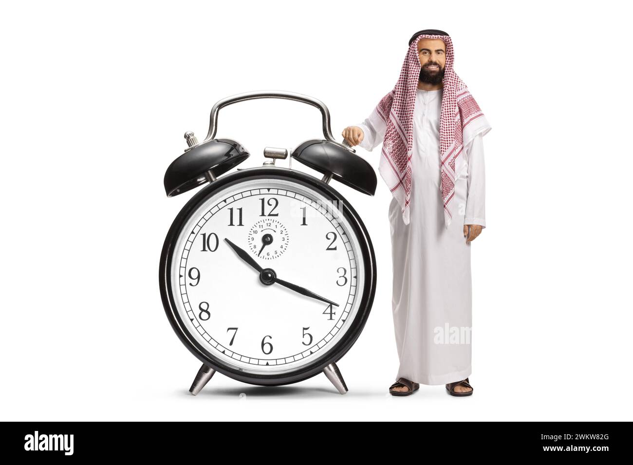 Saudi-arabischer Mann in ethnischer Kleidung mit einem großen Wecker isoliert auf weißem Hintergrund Stockfoto