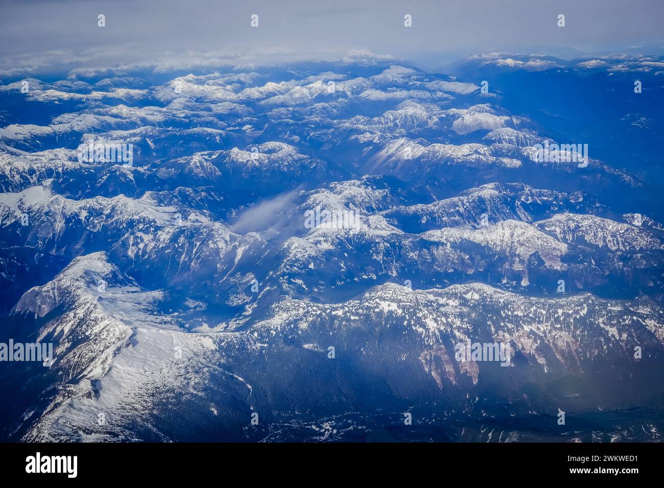 Aus der Vogelperspektive auf einen felsigen Berg, der während des kanadischen Winters teilweise mit Schnee bedeckt ist Stockfoto