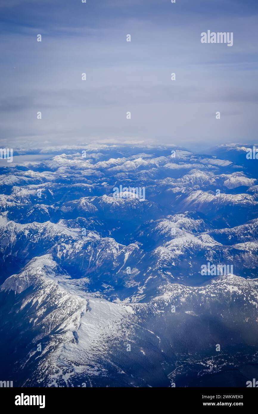 Aus der Vogelperspektive auf einen felsigen Berg, der während des kanadischen Winters teilweise mit Schnee bedeckt ist Stockfoto
