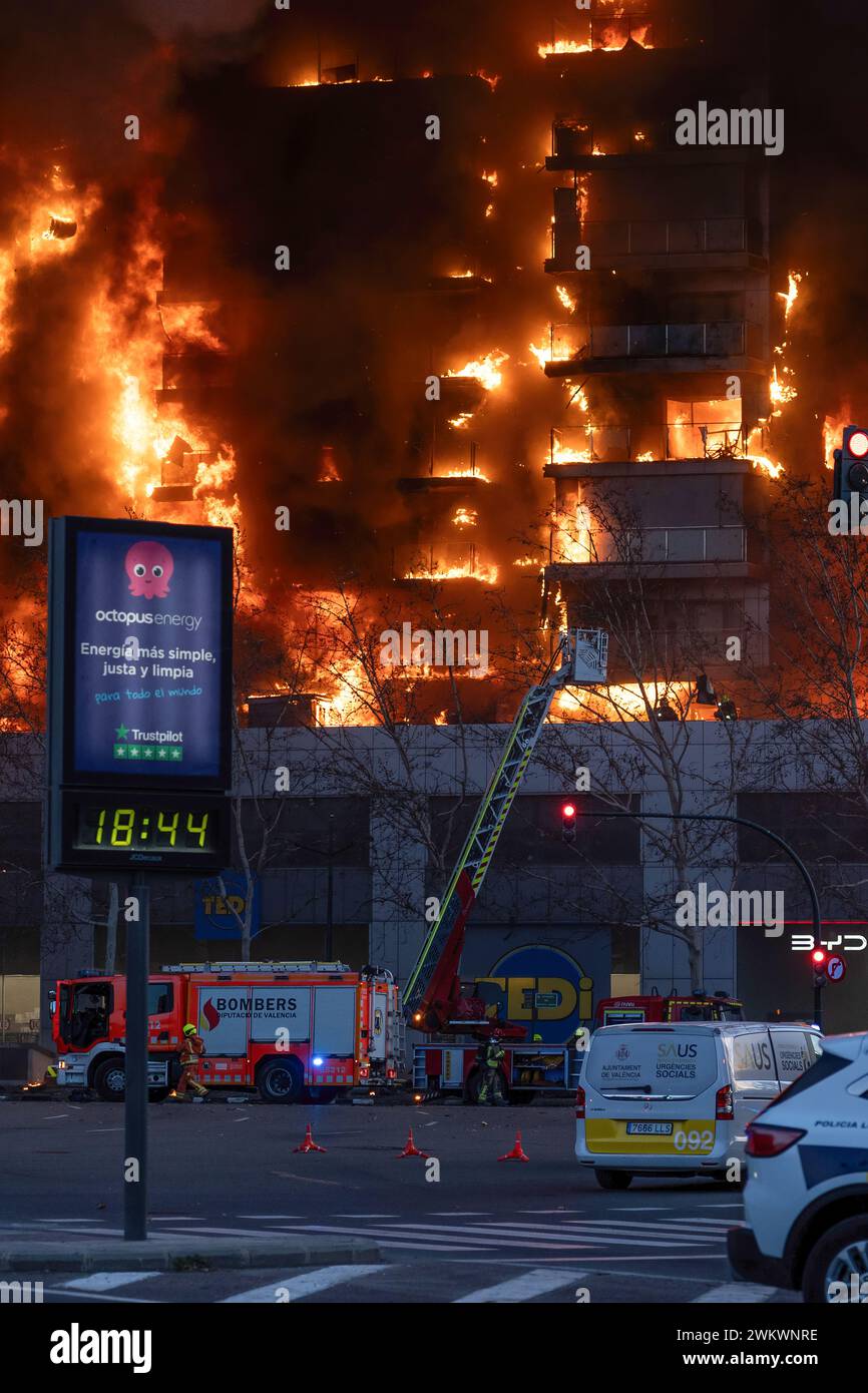 Valencia, Spanien - 22. Februar 2024: Eine Gruppe von Feuerwehrleuten entkommt einem großen Brand in einem Wohngebäude durch die Leiter des Lastwagens in der Stadt Stockfoto