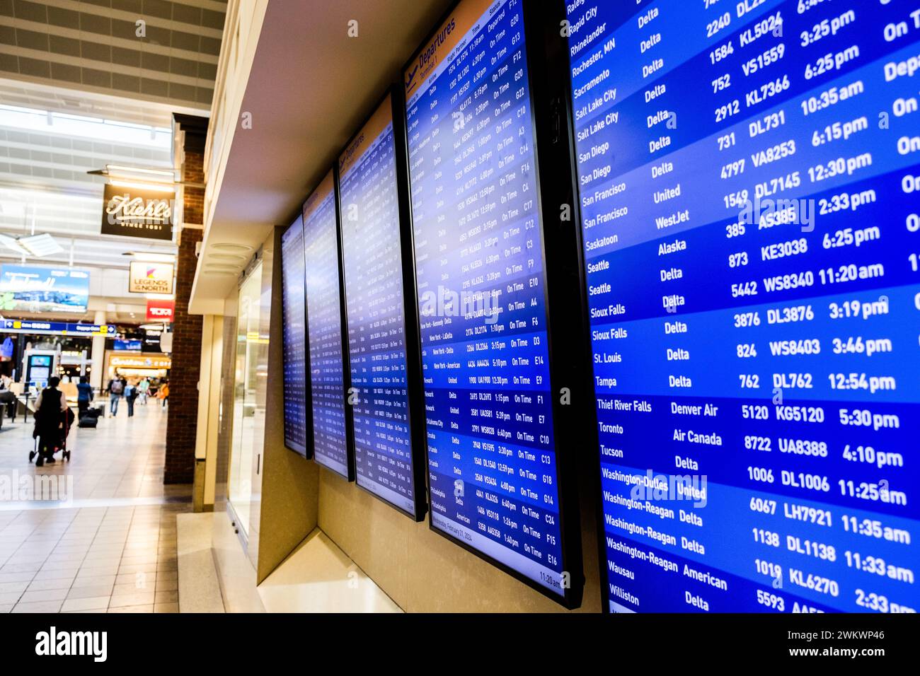 Fluggäste und die Anzeige von Ankunft und Abflug an der Minneapolis-St. Paul Airport, USA (MSP) während eines typischen Flughafentages. Stockfoto