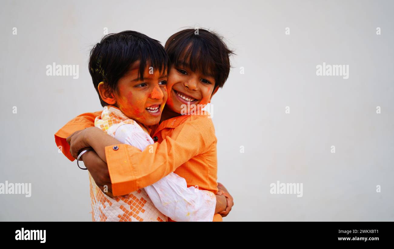 Fröhliche indische Kinder spielen Farben, lächeln mit Farben im Gesicht oder asiatische Kinder feiern Holi. Konzept für das indische Festival Holi. Helle Kinder verschmieren Stockfoto