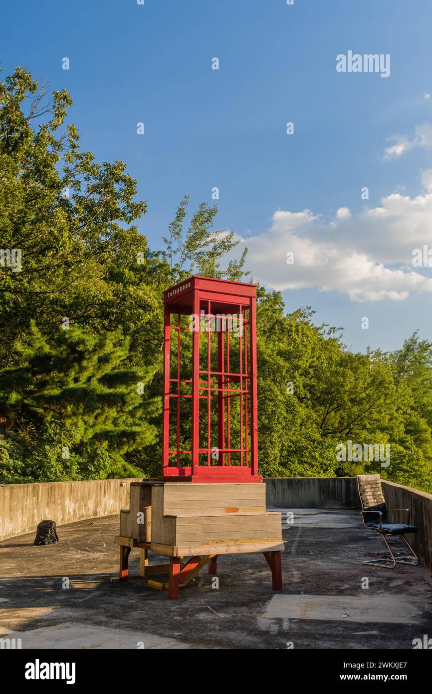 Rote hölzerne Telefonzelle ohne Telefon und ohne Glas auf dem Dach des Gebäudes an sonnigem Tag mit blauem Himmel in Südkorea Stockfoto