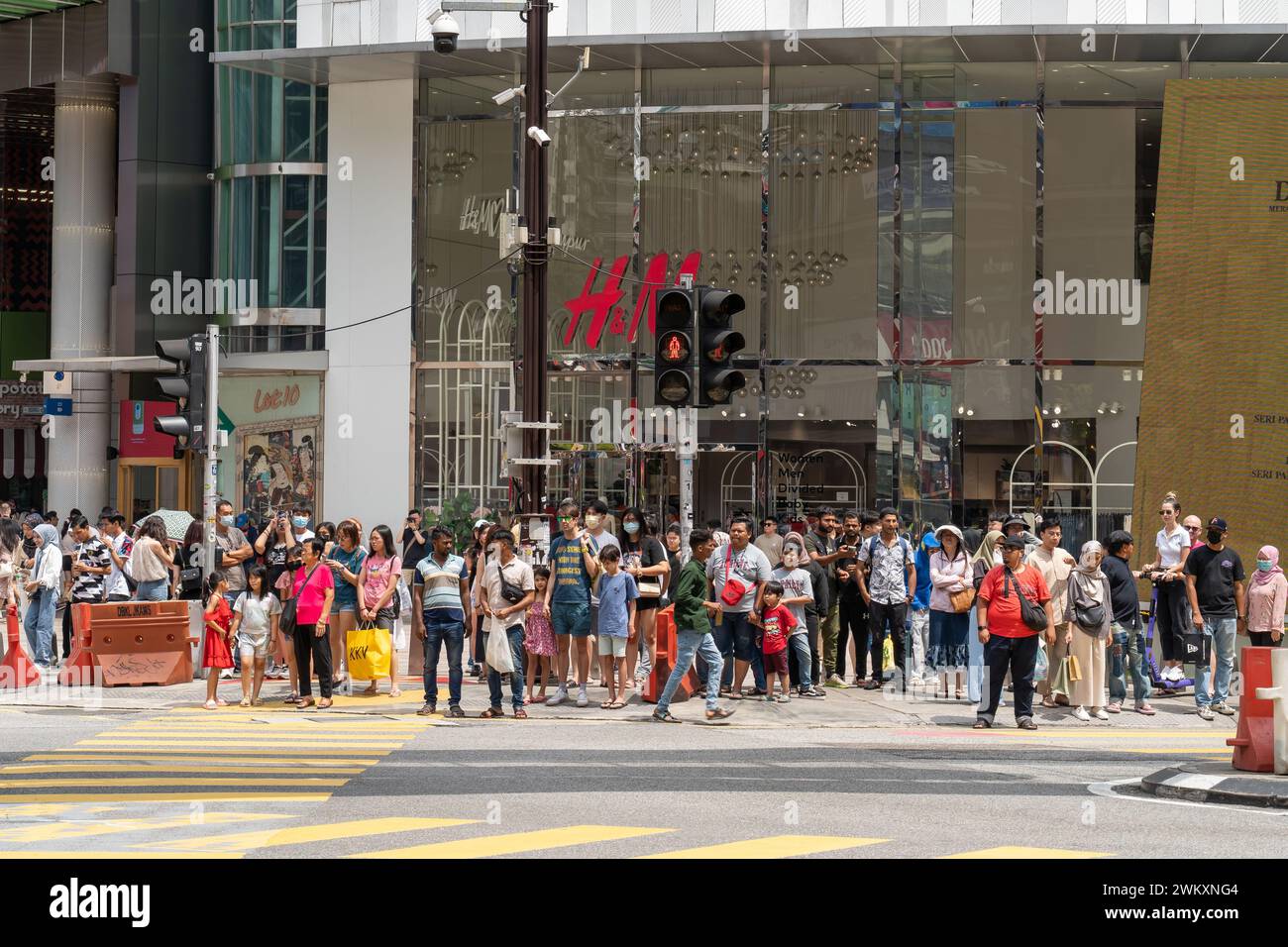 Kuala Lumpur, Malaysia : Februar 4,2024 : die Menschen können sehen, wie sie an einer Ampel warten, um die Straße vor dem Einkaufszentrum Lot 10 zu überqueren. Stockfoto