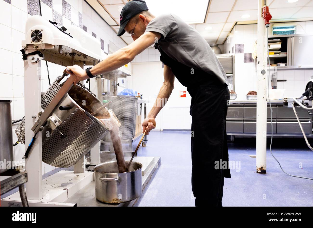 DEN BOSCH – Schokolade wird in der Bäckerei von Banketbakkerij Jan de Groot angezapft, wo Bossche Bollen hergestellt werden. De Bossche Bol gibt es seit hundert Jahren. ANP IRIS VAN DEN BROEK niederlande aus - belgien aus Stockfoto