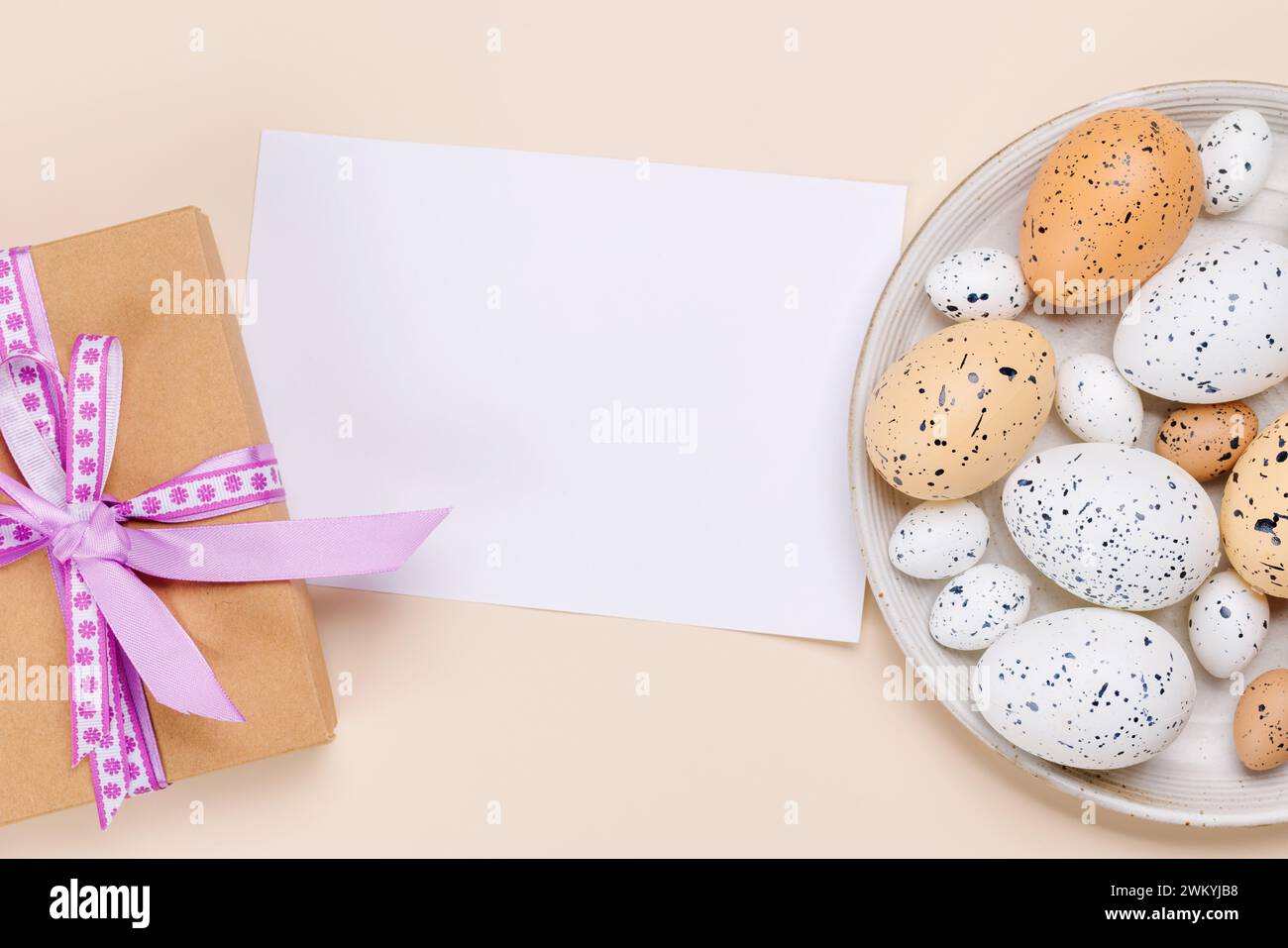 Osterfreuden: Bunte Eier in festlicher Anordnung und Geschenkbox. Flache Ladefläche mit Platz für Kartenkopien Stockfoto