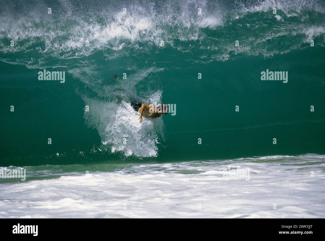 Ein junger Mann, der am Keiki Beach am Nordufer von Oahu, Hawaii, surft. Stockfoto