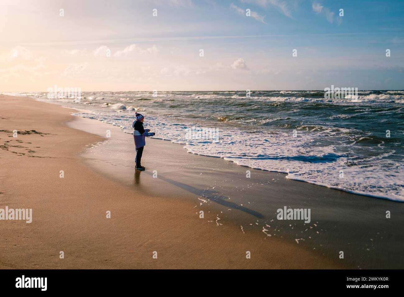 Junge, der im Winter am Strand an der Ostsee spielt Stockfoto