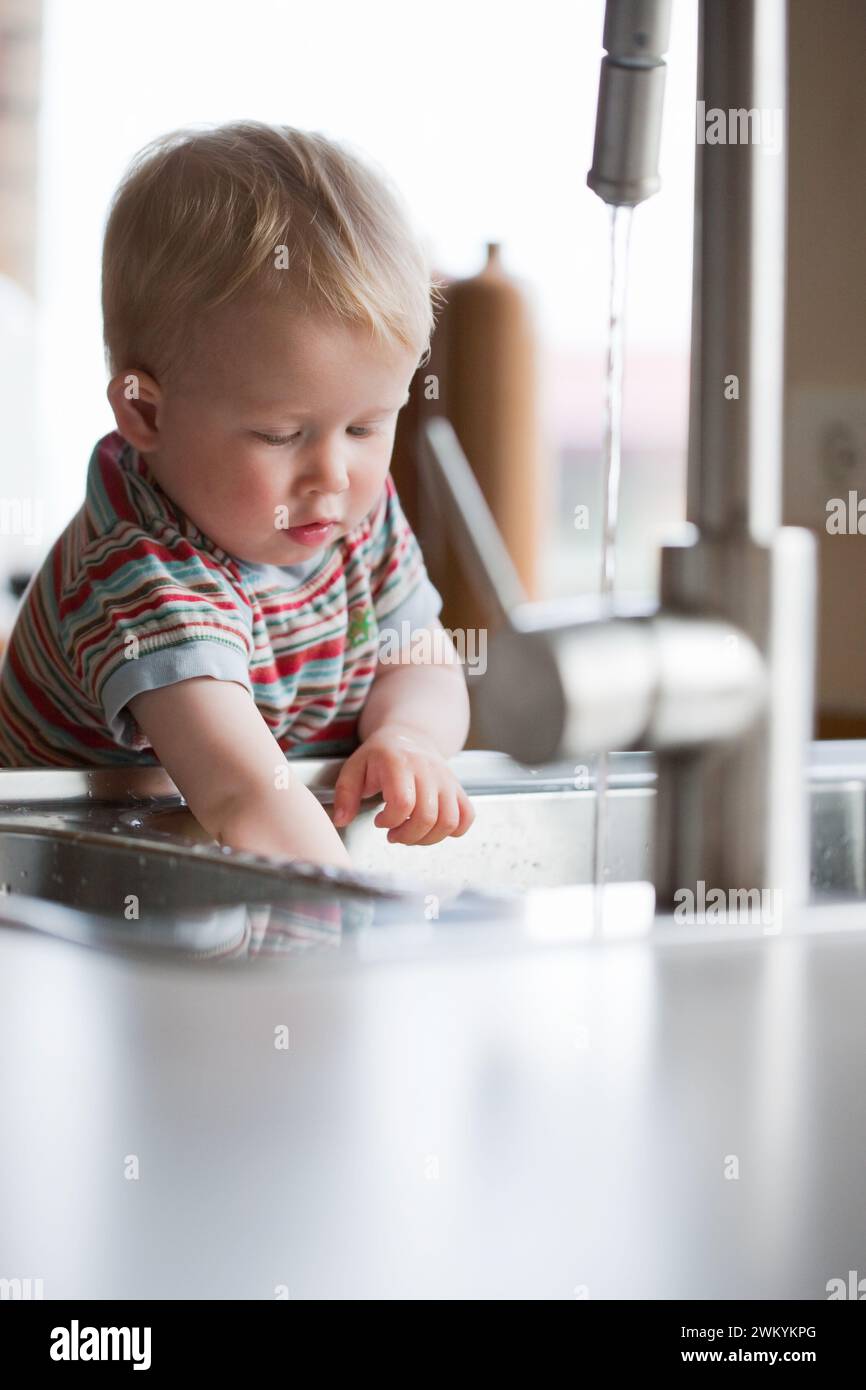 Kleinkind spielt in der Küche Stockfoto