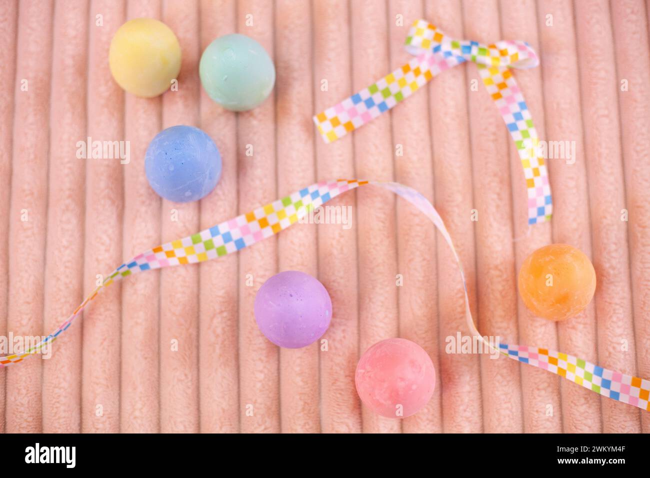 Osterflachlegen mit bunten Kreideeiern auf einer Pfirsichdecke Stockfoto