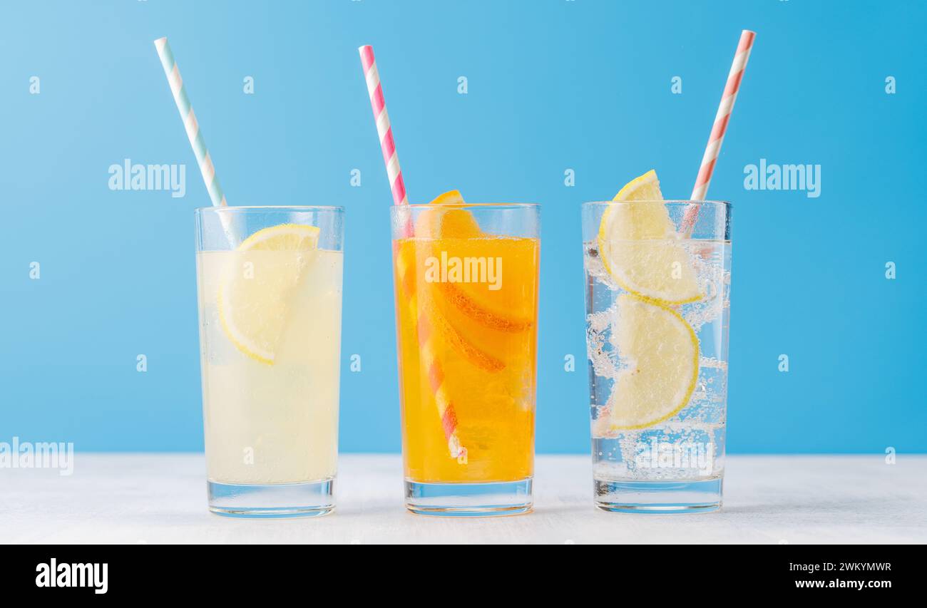 Verschiedene Limonade mit Eis in Gläsern auf blauem Hintergrund Stockfoto
