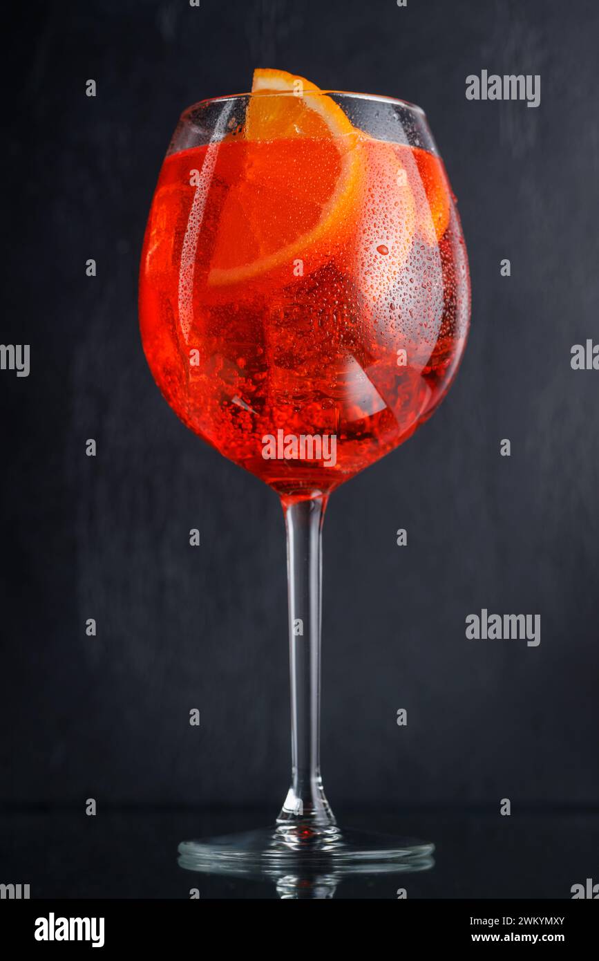 Aperol Spritz Cocktail mit Orangenscheibe und Eis auf dunklem Hintergrund Stockfoto