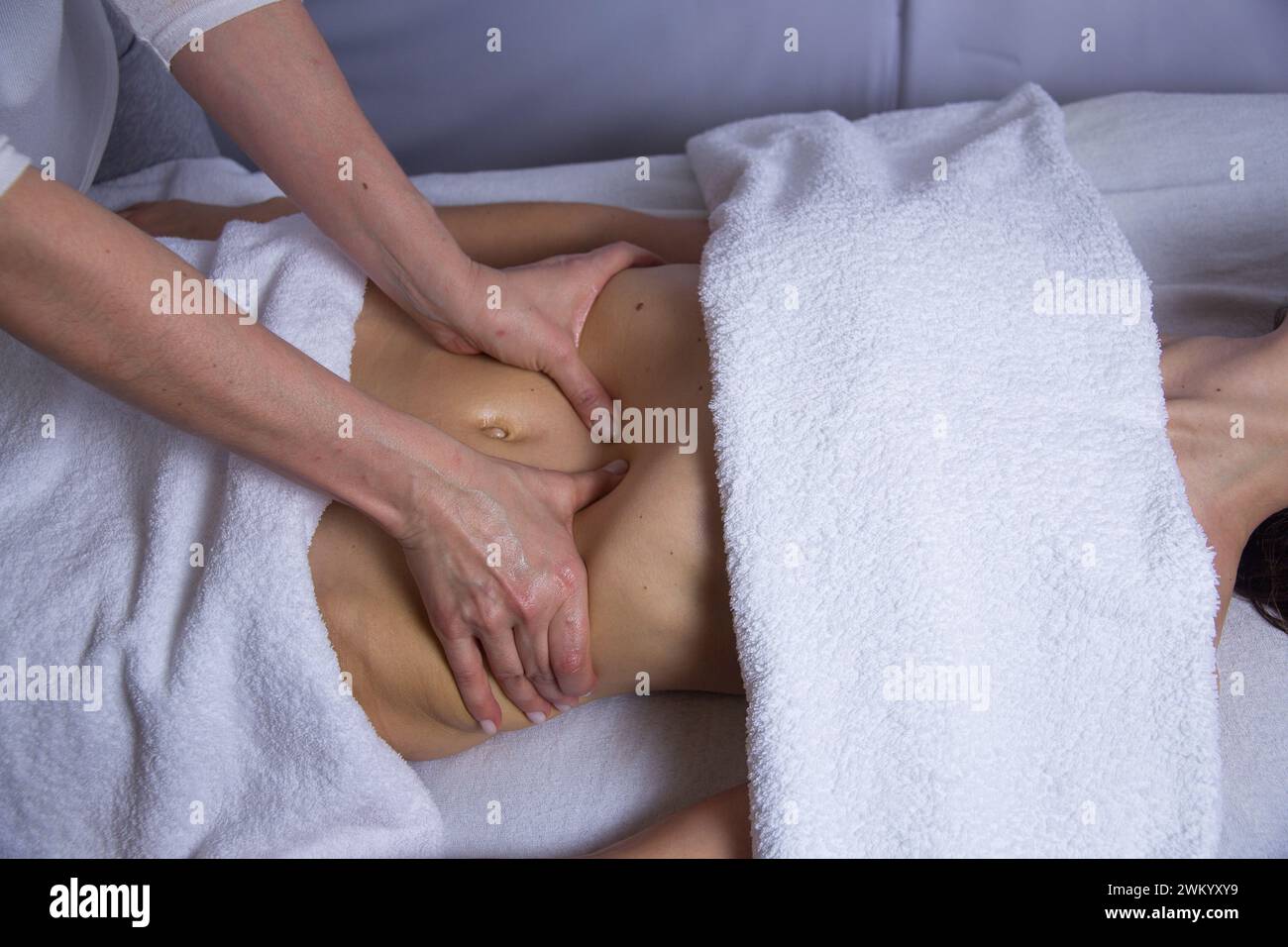 Hände einer Masseurin, die einer Frau in einem Spa-Salon eine Bauchmassage macht, Entspannungskonzept, Kopierraumkonzept Stockfoto