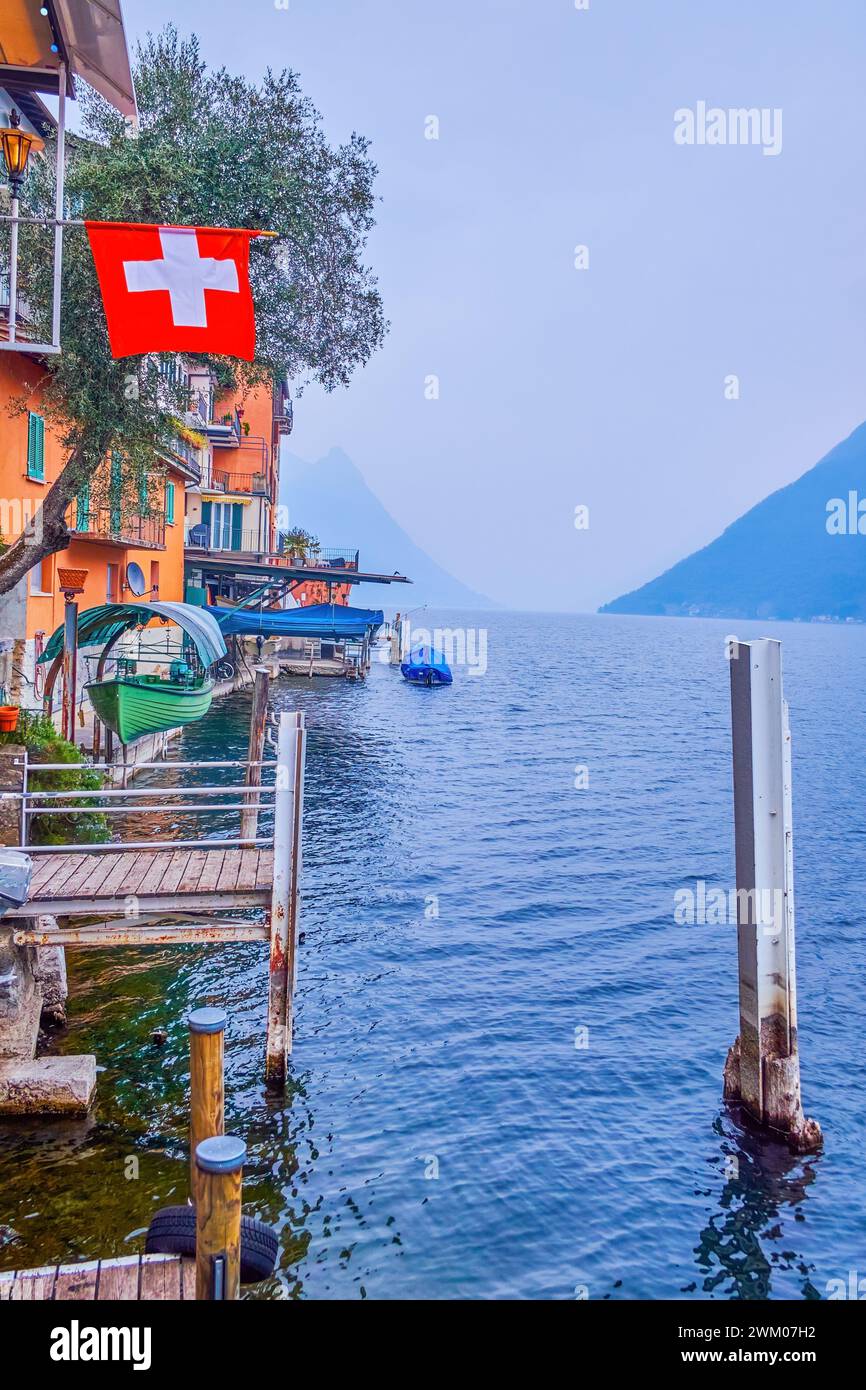 Die Häuser am See mit überdachten Bootslagern auf Liften, Luganer See in Gandria, Schweiz Stockfoto