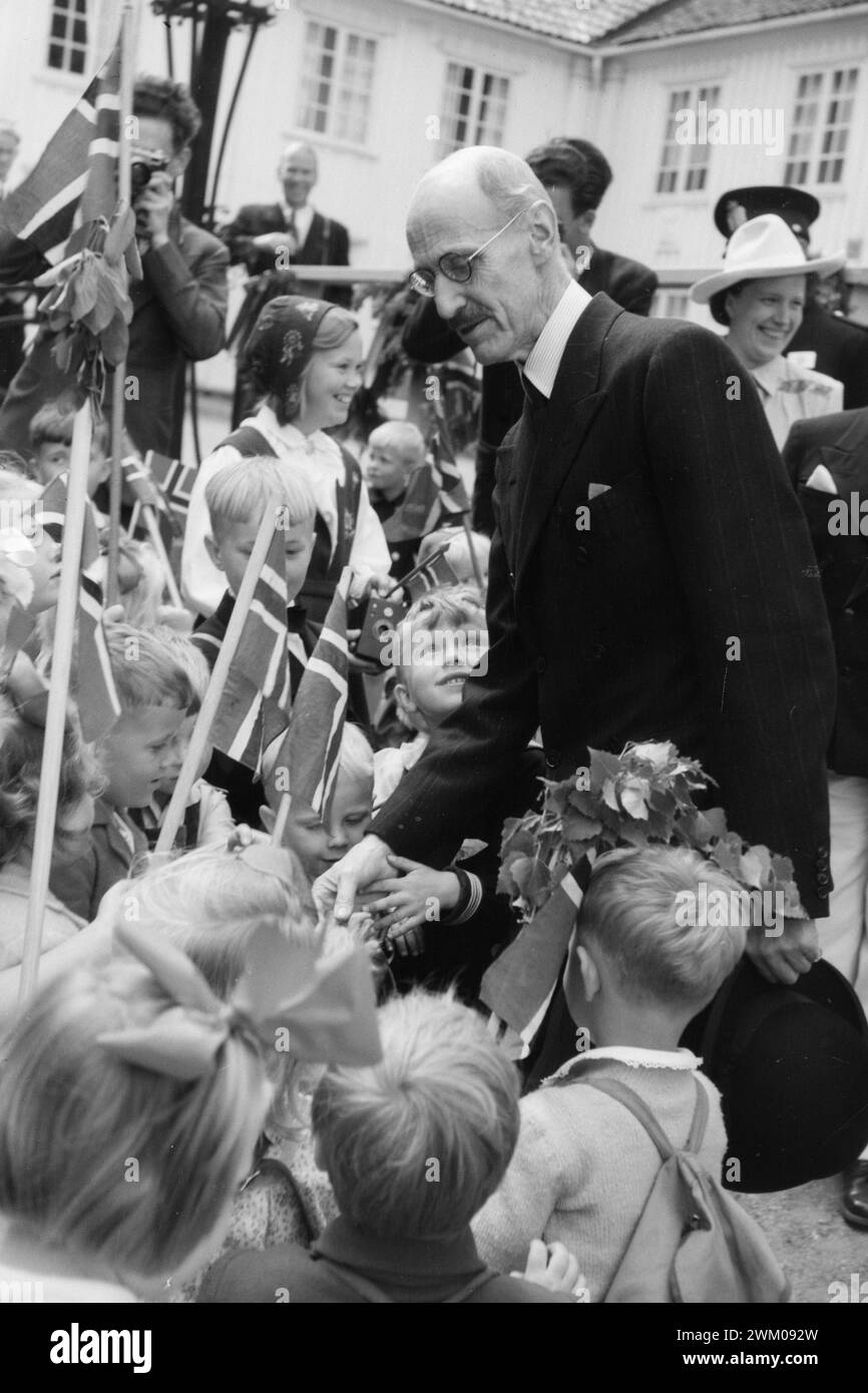 Aktuell 13-1946: Mit dem König bei der Grenzpartei. Die Grenzgänger bei einer Party um ein Gebäude und eine Brücke. Halden. „Guten Tag, König!“ feuert den jüngsten Halden gegen König Haakon und erhält glückliches Lächeln und freundliche Worte als Antwort. Während des Besuchs des Königs in Halden fuhren die Kinder in einem großen Zug zum Gutshof Rød, wo seine Majestät lebte, um unserem kindliebenden und menschenliebenden König zu ehren. König Haakon VII. Begrüßt Kinder mit Fahnen. Foto: Th. Skotaam / aktuell / NTB ***Foto wird nicht verarbeitet*** Stockfoto