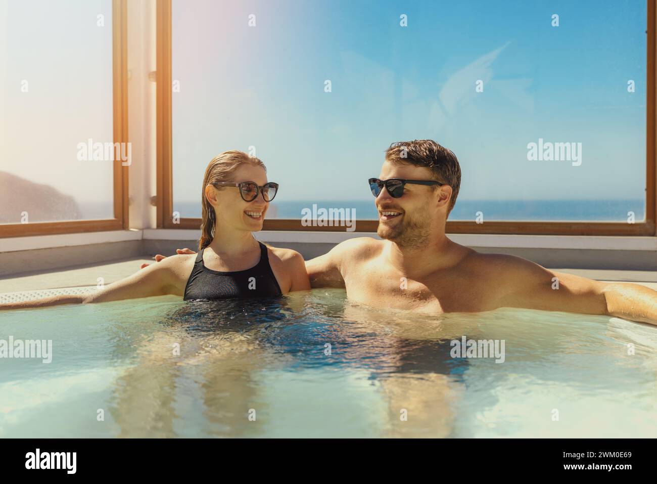 Ein Paar, das sich am sonnigen Tag im Jacuzzi auf dem Dach entspannt. Sommerurlaub, Kurzurlaub Stockfoto