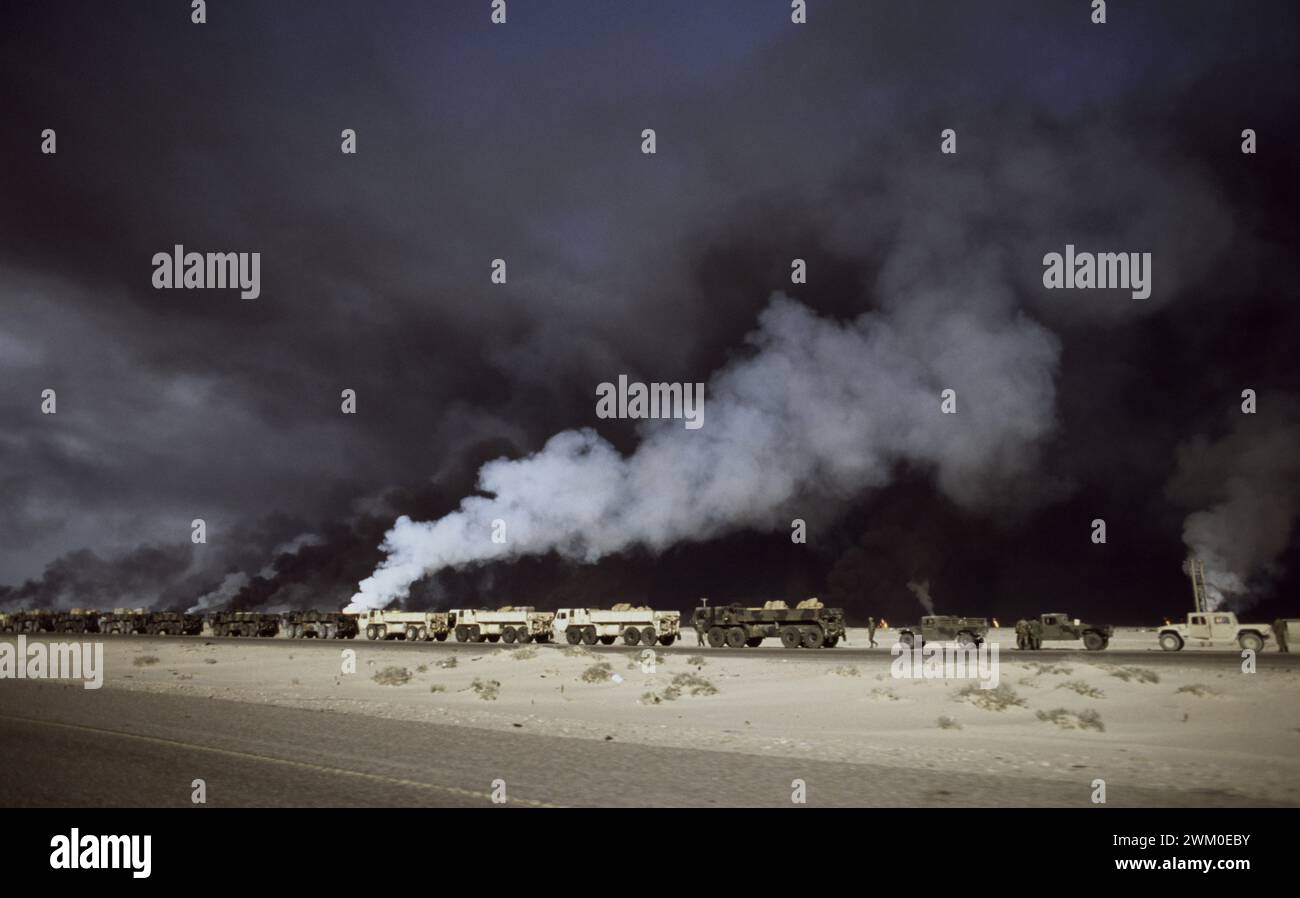 Erster Golfkrieg: 17. März 1991 brennende Ölquellen im Ölfeld Rawdatayn im Norden Kuwaits bilden einen dramatischen Hintergrund für einen Konvoi der US-Armee auf dem Basra Highway. Humvees übernimmt das Heck einer Serie von M977 Heavy Expanded Mobility Tactical Trucks (HEMTTs). Stockfoto