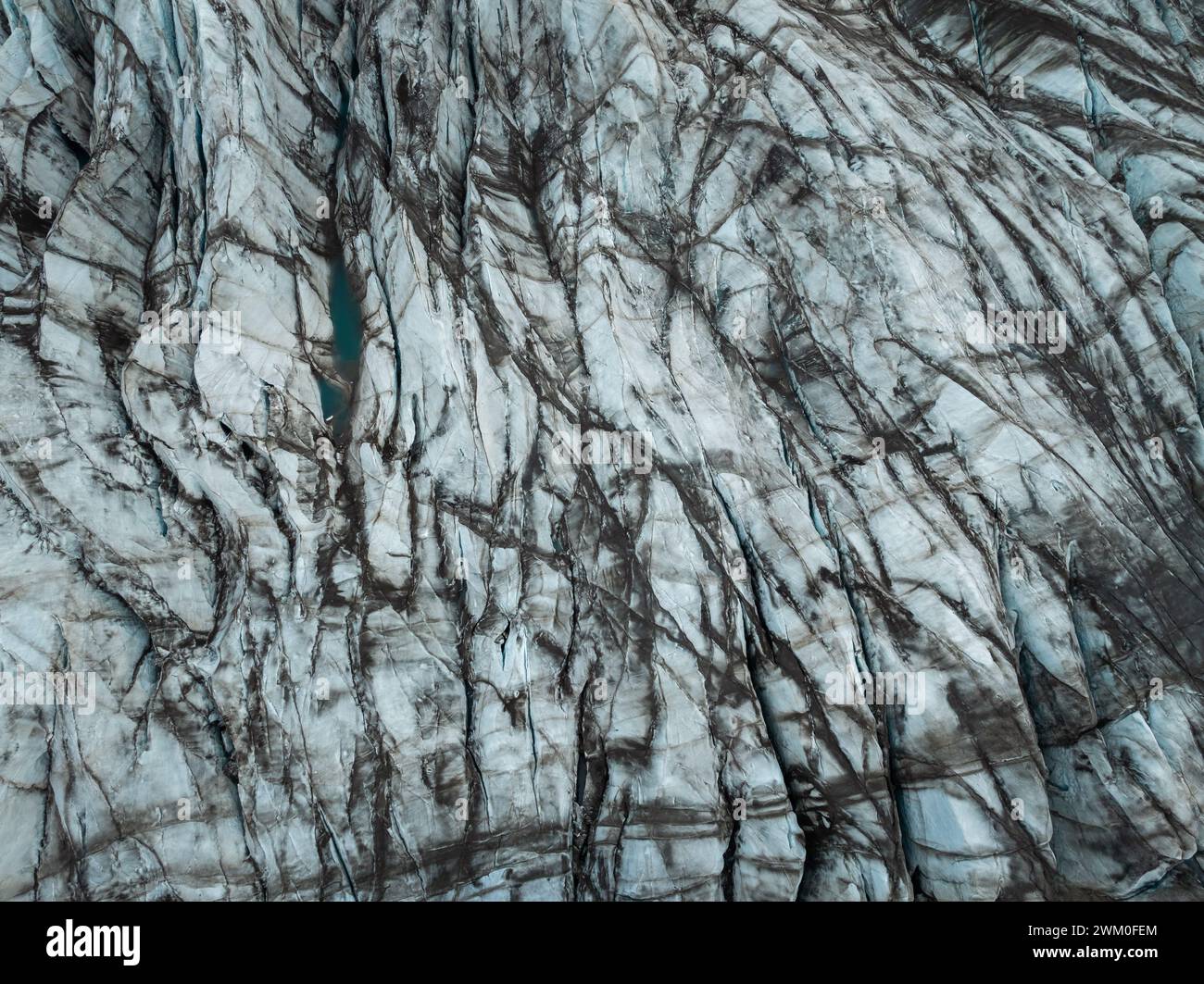 Dunkelgraue vulkanische Gesteinsformation, die aus gekühlter Lava gebildet wurde, aus der Luft oben nach unten geschossen. Naturhintergrund, Textur und Musterkonzepte. Stockfoto