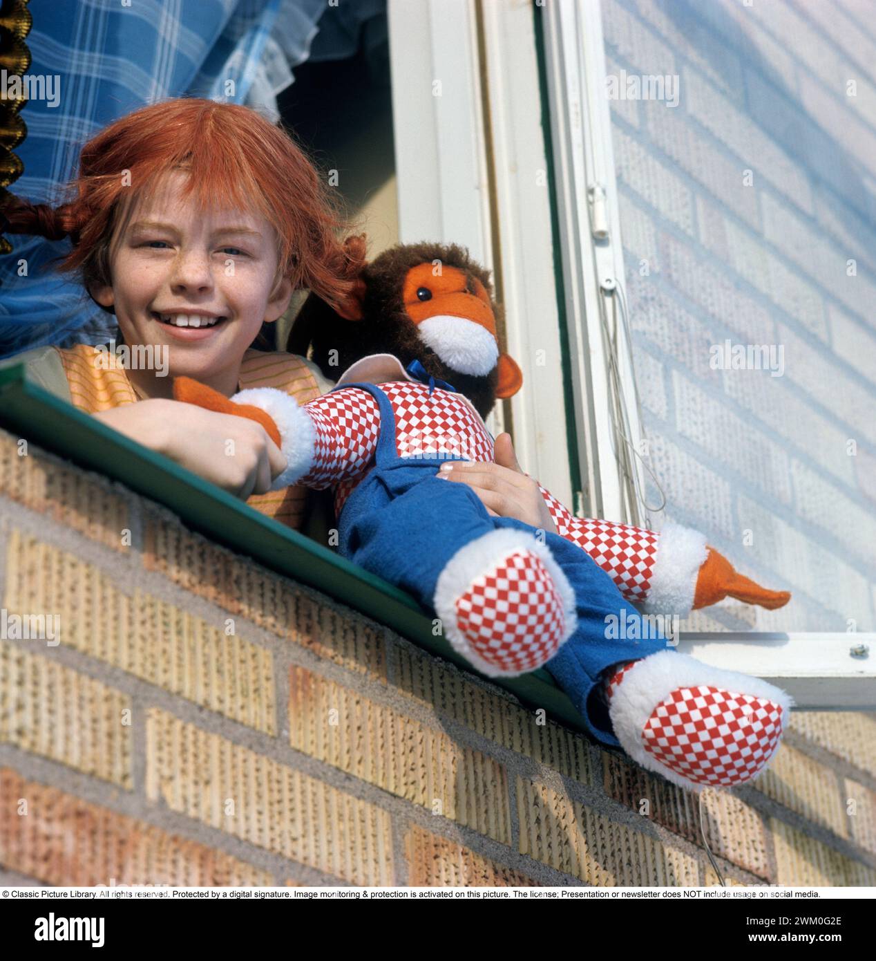 Inger Nilsson. Geboren 1959. Schwedische Kinderdarstellerin, bekannt für die Rolle des Pippi Langstrumpf in der Fernsehserie und in Filmen, die auf der Figur der Autorin Astrid Lindgren basieren. Hier gekleidet mit Pippi-Klamotten und roten Haaren in Zöpfen. Ein Kuscheltier repräsentiert den Affen Herr Nilsson, der in den Filmen zu sehen war. 17. Februar. 1970 *** Lokale Beschriftung *** Stockfoto