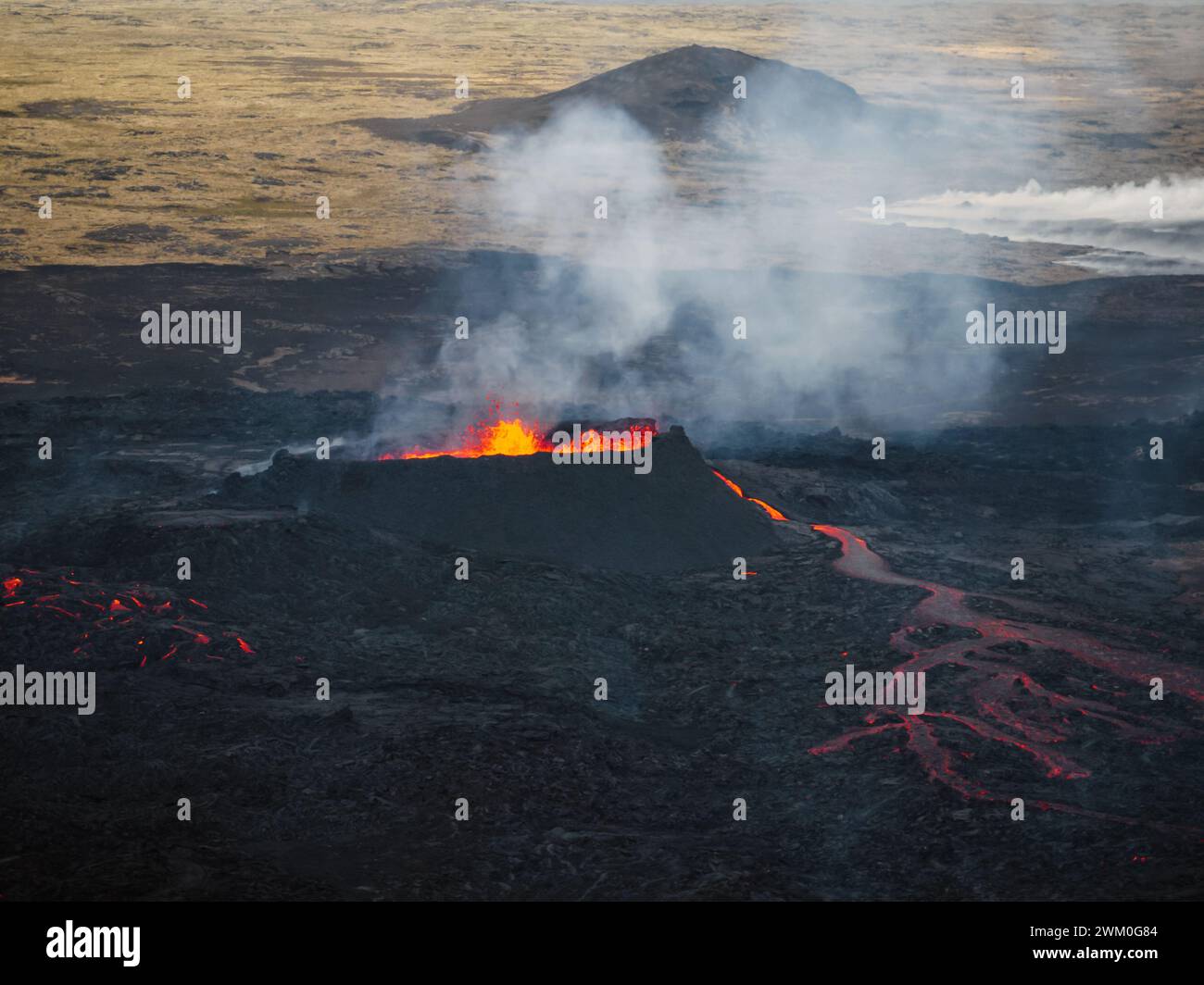 Fließende Lava, heißes Magma, das aus dem Vulkankrater fließt, Seitenansicht aus der Luft. Konzepte von Vulkanausbruch und isländischem Feuer- und Eisland. Stockfoto