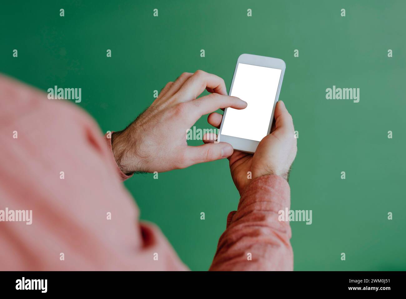 Mann, der ein Smartphone in der Nähe der grünen Wand benutzt Stockfoto