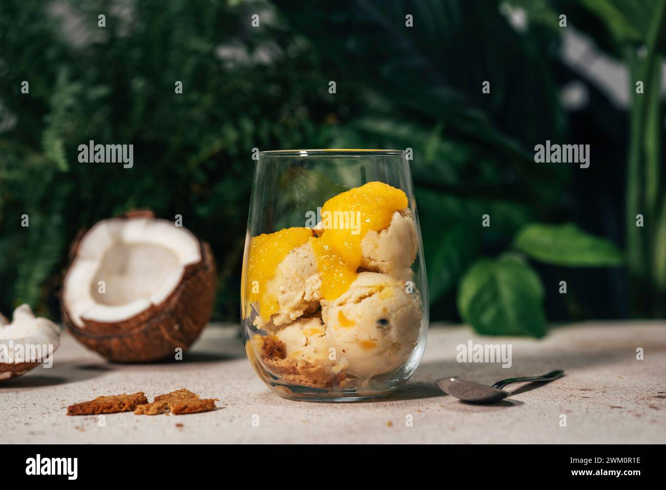 Erfrischendes Kokos-Eis mit Obstsauce im Glas Stockfoto
