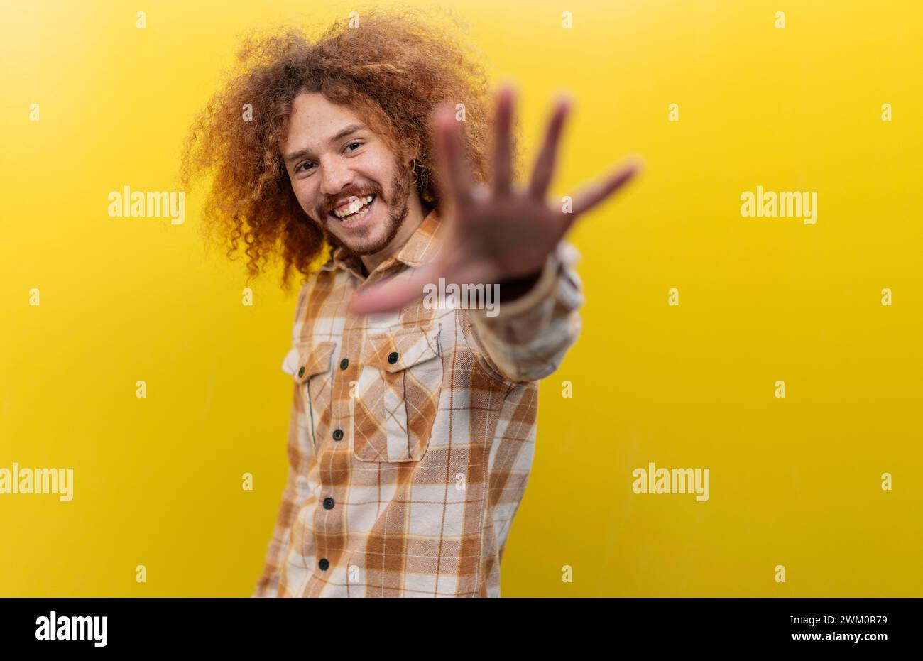 Mann zeigt Stop-Geste vor der gelben Wand Stockfoto