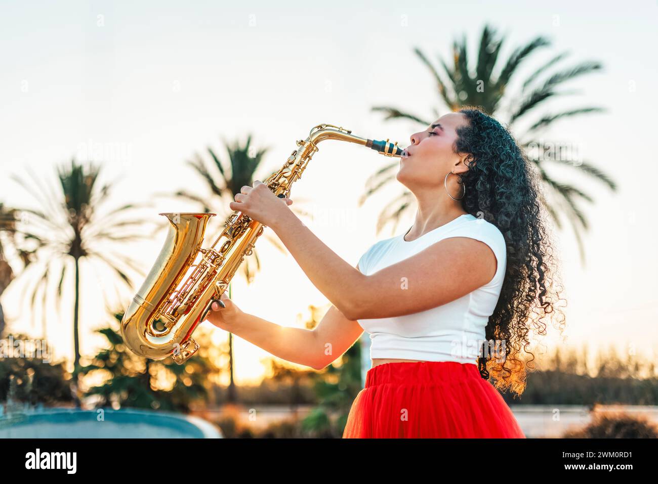 Leidenschaftliche Frau, die Saxophon im Skatepark spielt Stockfoto