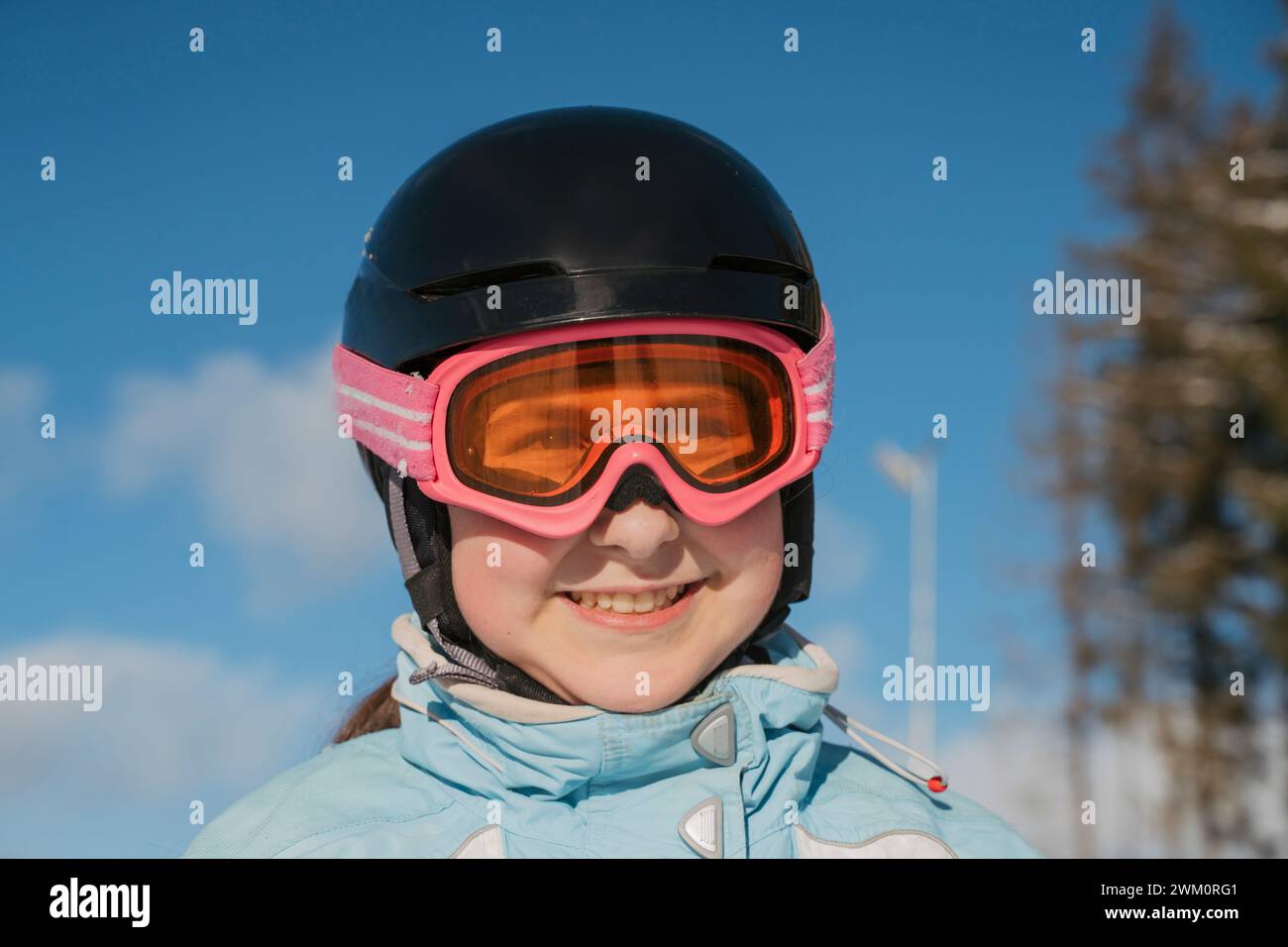 Lächelndes Mädchen mit Skibrille im Resort Stockfoto