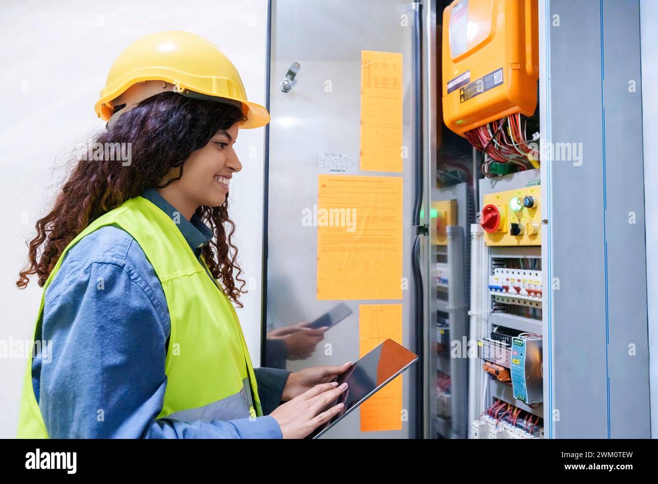 Lächelnder Ingenieur hält Tablet-PC in der Nähe des Servers Stockfoto