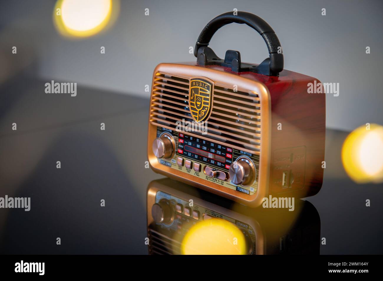 Vintage-Radio auf orangem Hintergrund in schwach beleuchtetem Raum mit goldenen Akzenten Stockfoto