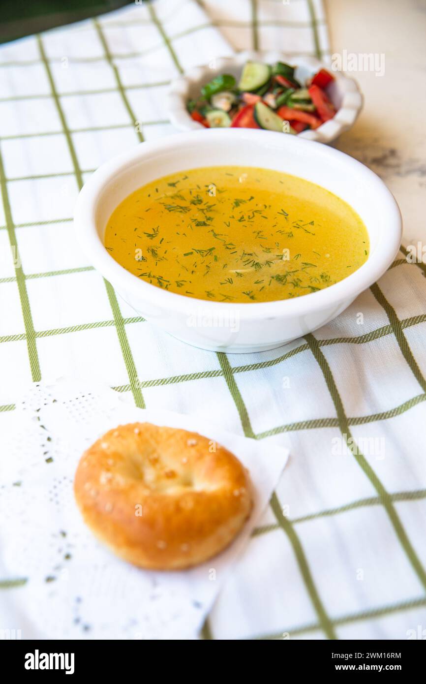 Usbekische Nationalgerichte, Plov, Shurpa, Salat und nicht auf einem Tablett mit Tee. Traditionelle usbekische Küche. Hintergrund mit kariertem Tischtuch. Stockfoto