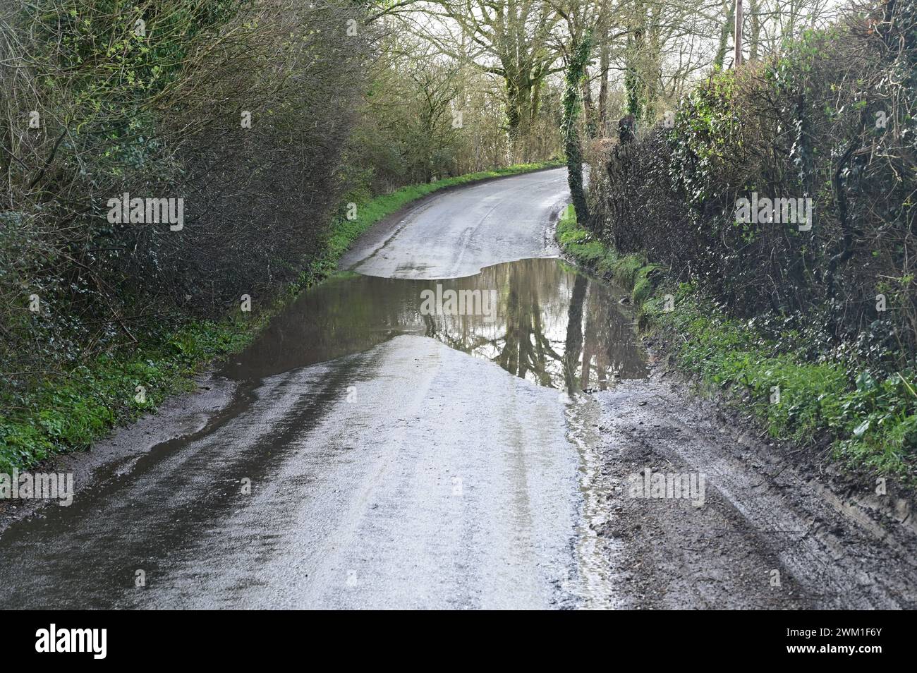 Überflutete, schlammige, rutschige, schmutzige Straße in Großbritannien nach den starken Regenfällen vom 22. Februar 2024. Stockfoto