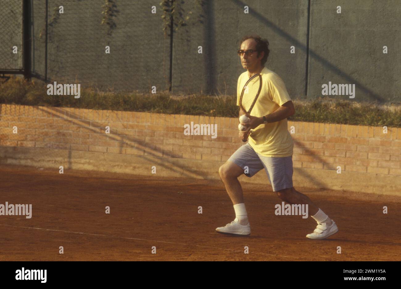 MME4745276 Jean-Luc Godard spielt Tennis, 1983 (Foto); (Filmfestival Venedig add.info.:, 1983. Der englische Regisseur Jean-Luc Godard spielt auf dem Tennisplatz des Excelsior Hotels/Mostra del Cinema di Venezia. Er meldete Jean-Luc Godard bei Tennis im campi dellL’Hotel Excelsioer an; © Marcello Mencarini. Alle Rechte vorbehalten 2024. Stockfoto