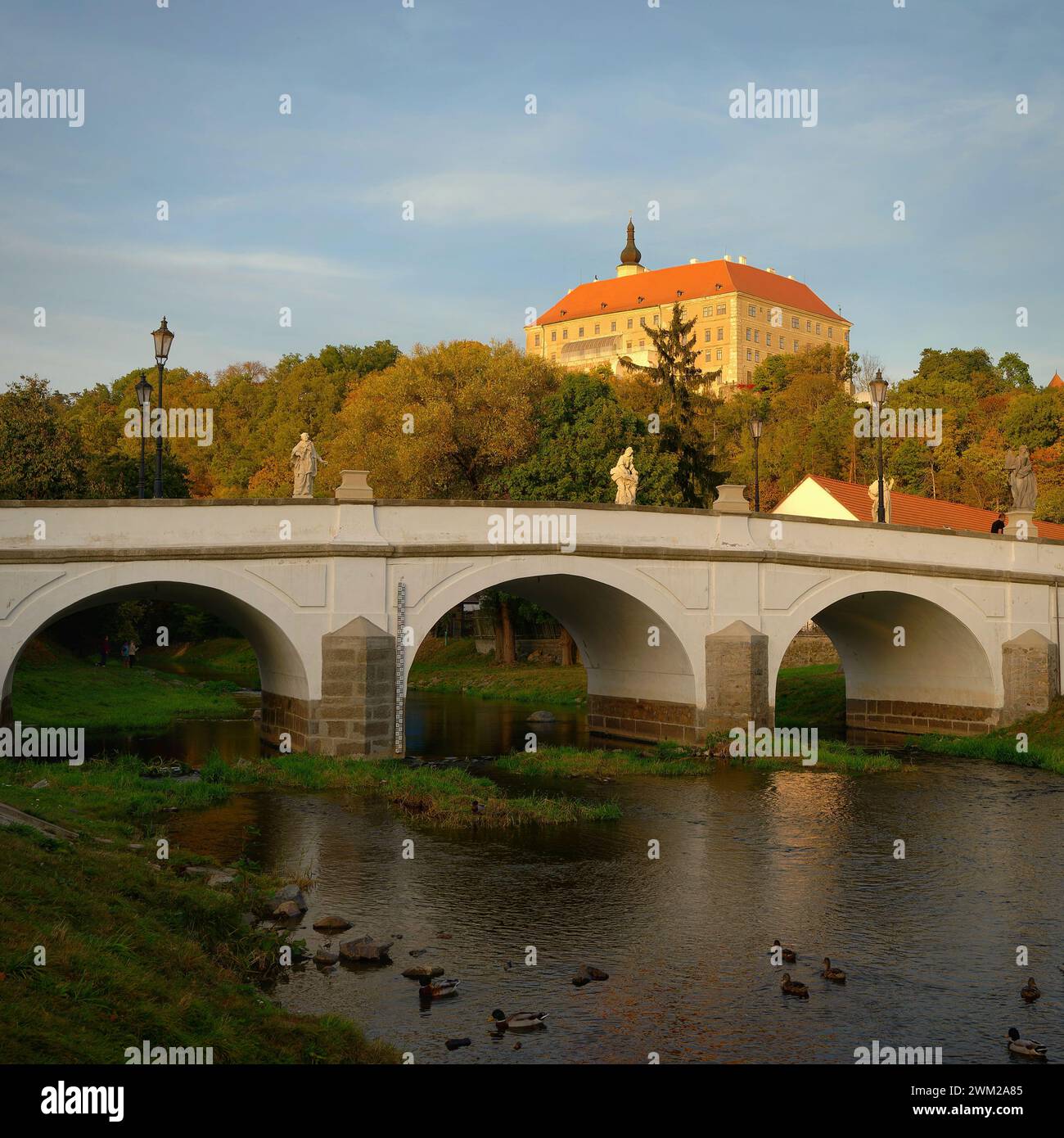 Wunderschönes altes Schloss mit einer Brücke über den Fluss bei Sonnenuntergang. Alte europäische Architektur. Namest nad Oslavou - eine Stadt in der Tschechischen Republik. Stockfoto