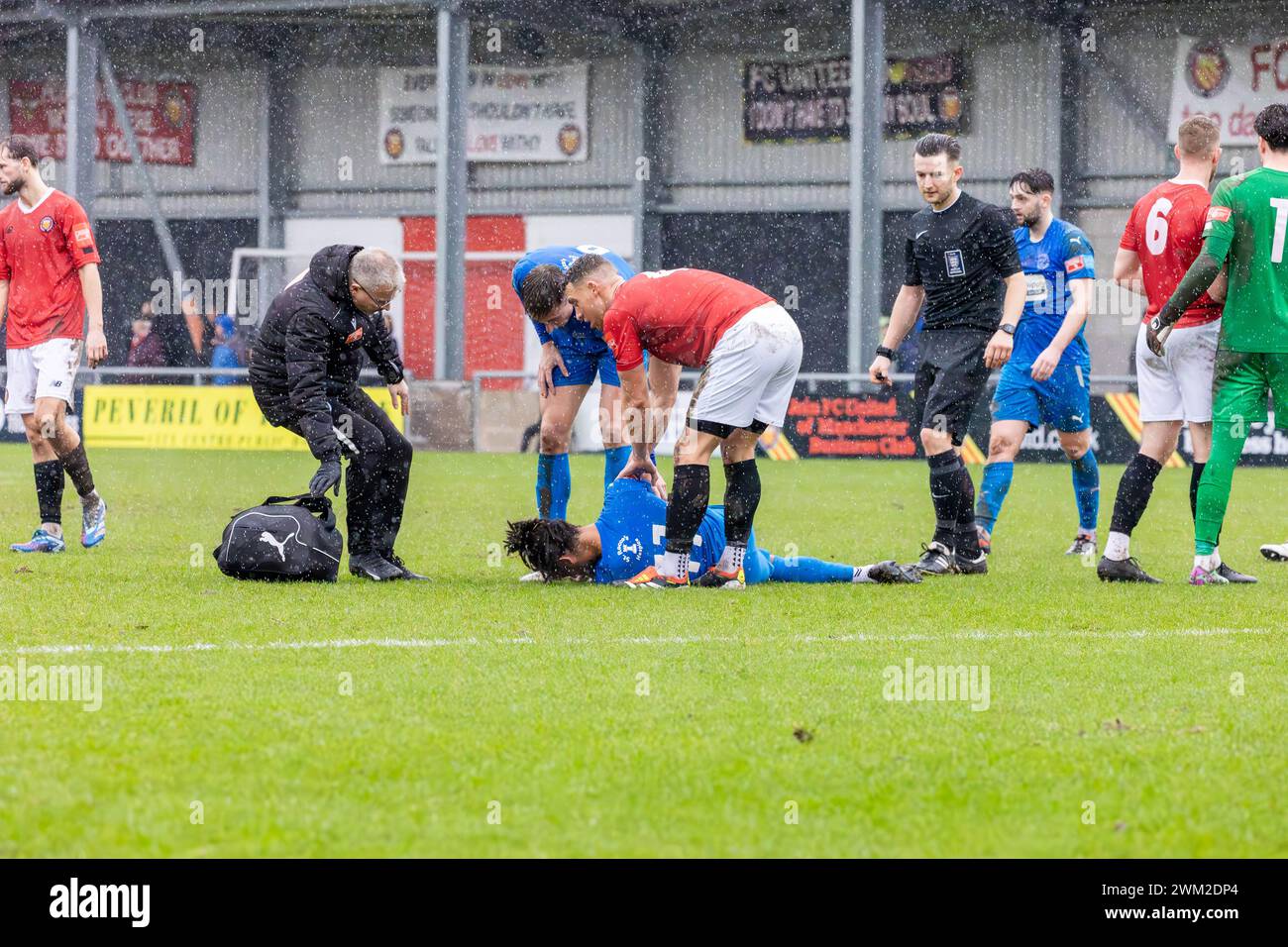 Der Fußballspieler Djavan Pedro liegt im Broadhurst Park verletzt, als der Sportphysio Carl Rutter dabei ist Stockfoto Der Fußballspieler Djavan Pedro liegt im Broadhurst Park verletzt, als der Sportphysio Carl Rutter dabei ist Stockfoto