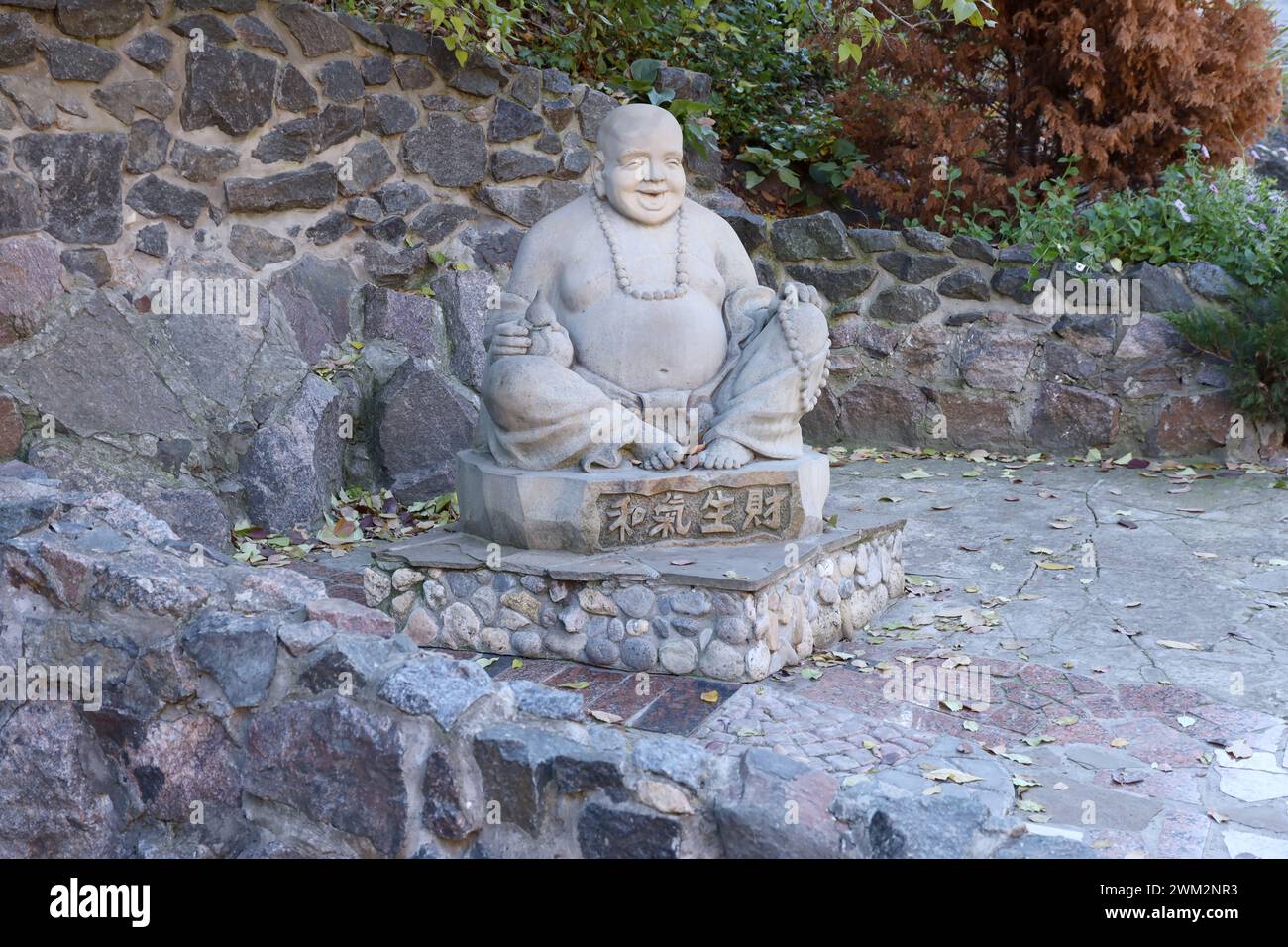 Cherkasy, UKRAINE - 20. OKTOBER 2021 Joyful Buddah Betonstatue in Grau nahe dem Weißen Lotus buddhistischen Tempel in Tscherkasy, Ukraine Stockfoto