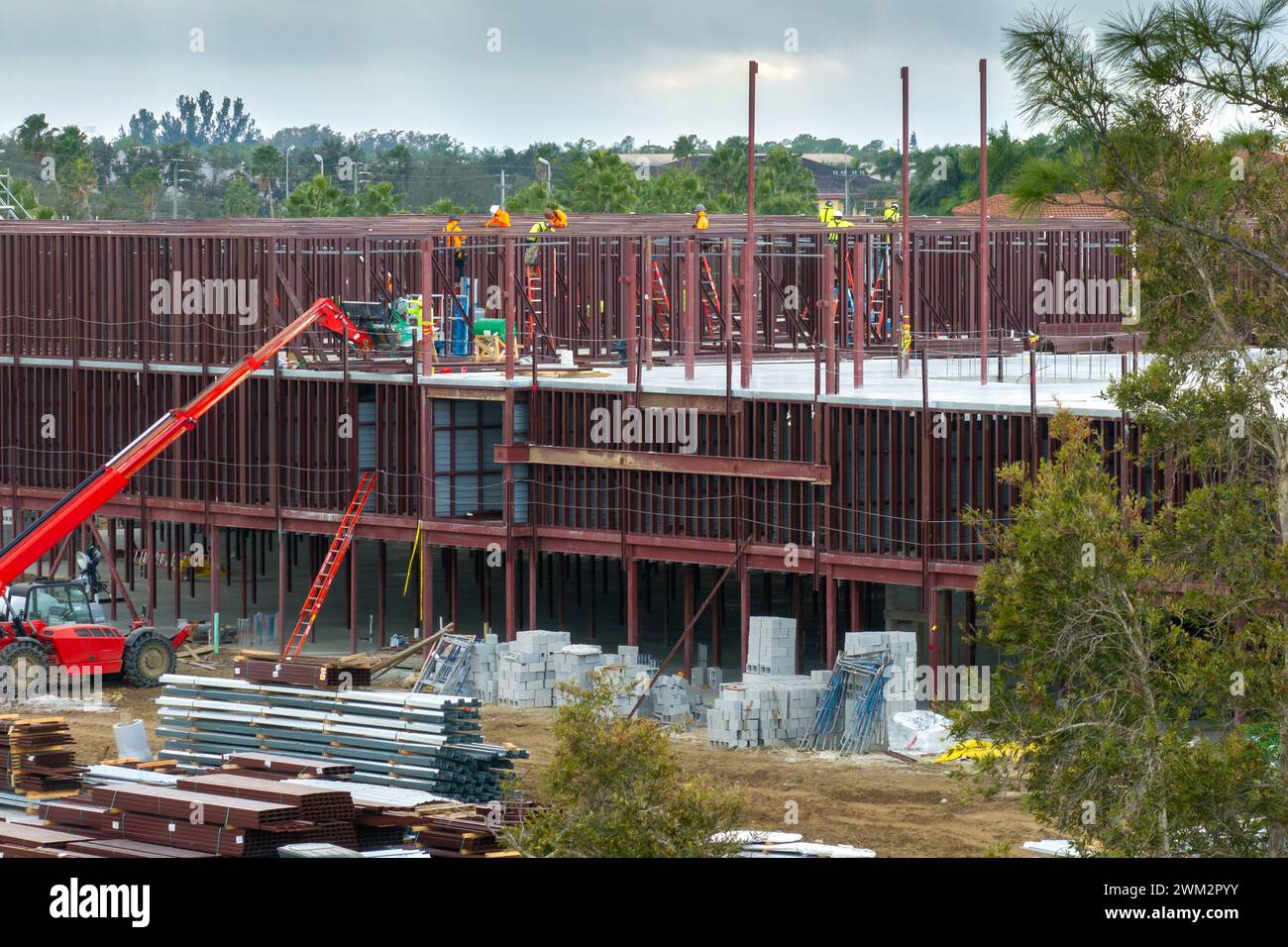 Arbeiter, die Metallrahmengebäude auf einer Industriebau montieren. Wohnungsentwicklung in Amerika. Immobilienmarkt in den USA Stockfoto