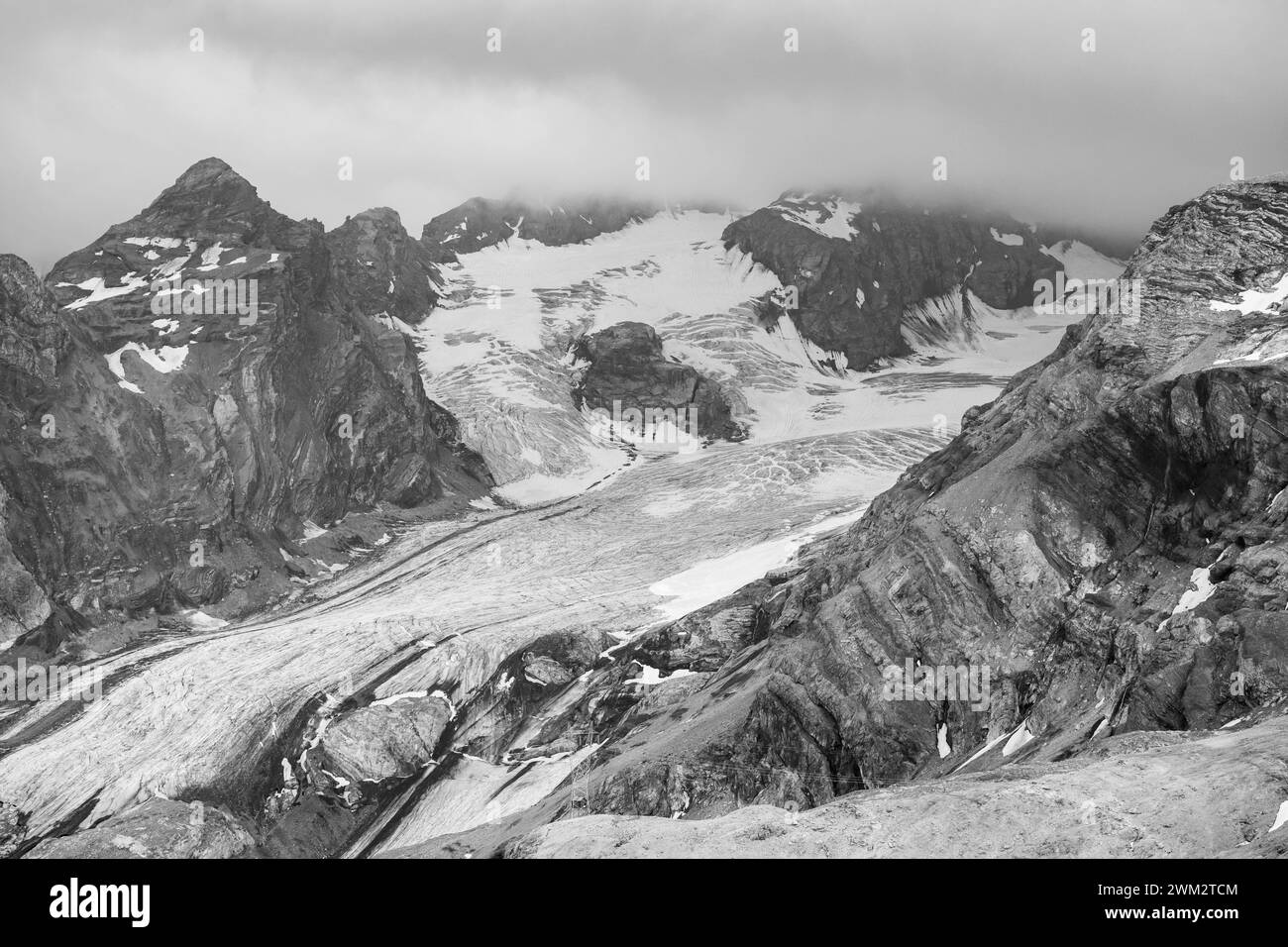 Die Ortler Alpen nahe dem Stelvjoch bei Sonnenuntergang im Sommer, Wolken um den Gipfel, schwarz-weiße Stilfs Schweiz Stockfoto