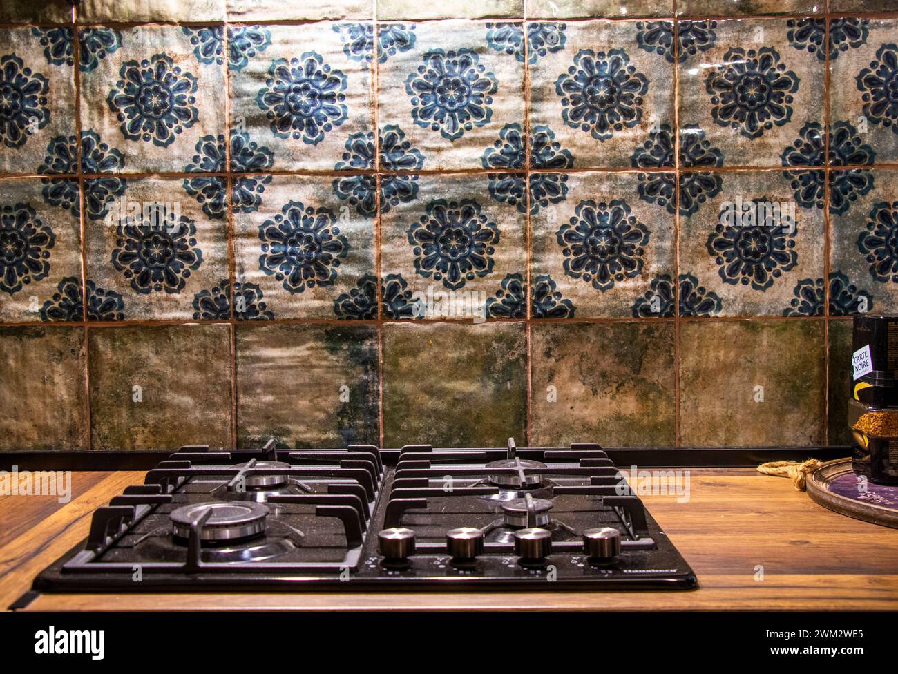 Herd und Ofen neben blau gekachelten Wänden Stockfoto