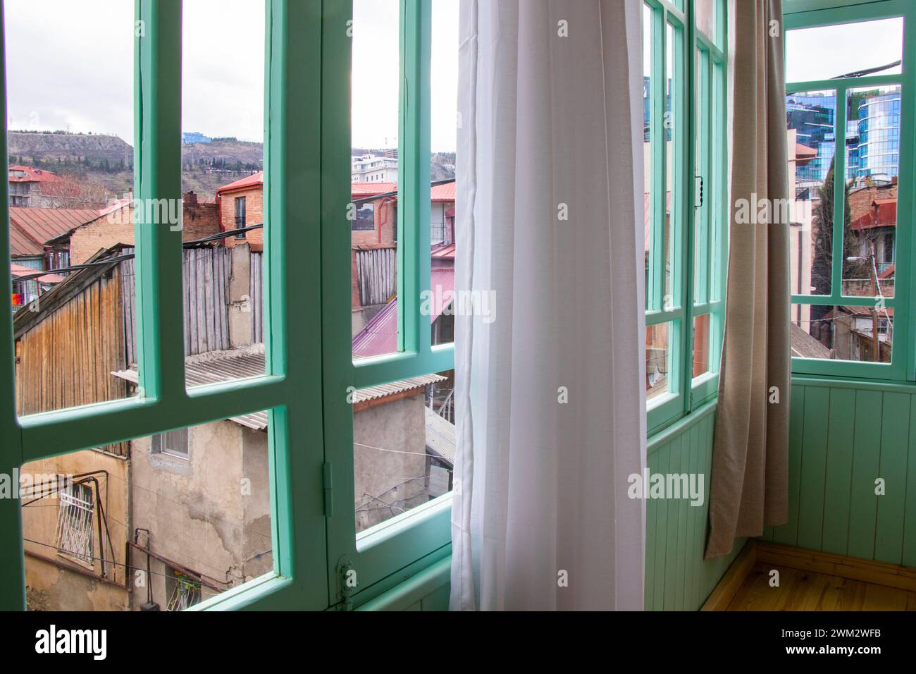 Offenes Fenster mit Vorhängen, die draußen wehen Stockfoto