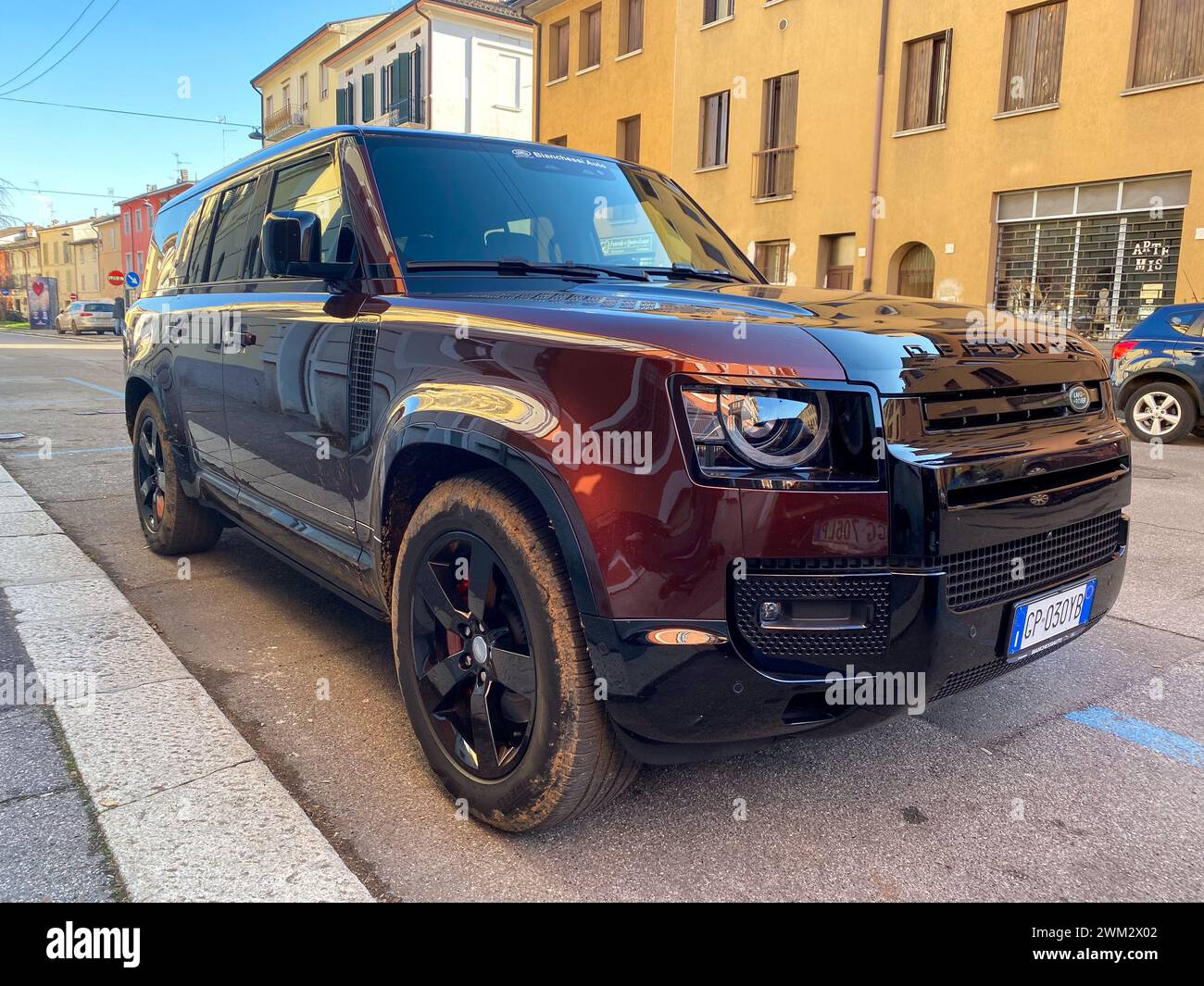 Cremona, Italien - 15. Februar 2024 Land Rover Defender 130 SE Sedona Red suv geländewagen in Parkposition. Stockfoto