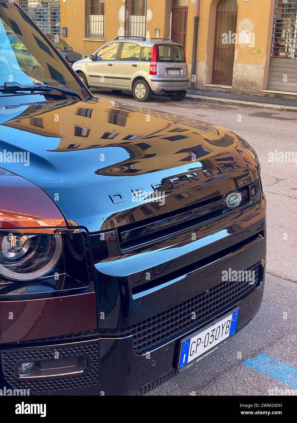 Cremona, Italien - 15. Februar 2024 Land Rover Defender 130 SE Sedona Red suv geländewagen in Parkposition. Stockfoto