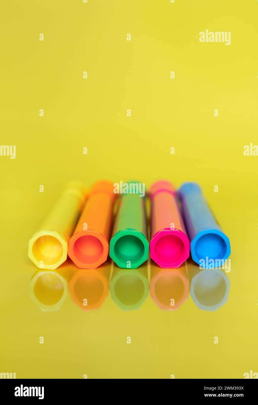 Farbige fluoreszierende Textmarker auf hellgelbem Hintergrund Stockfoto