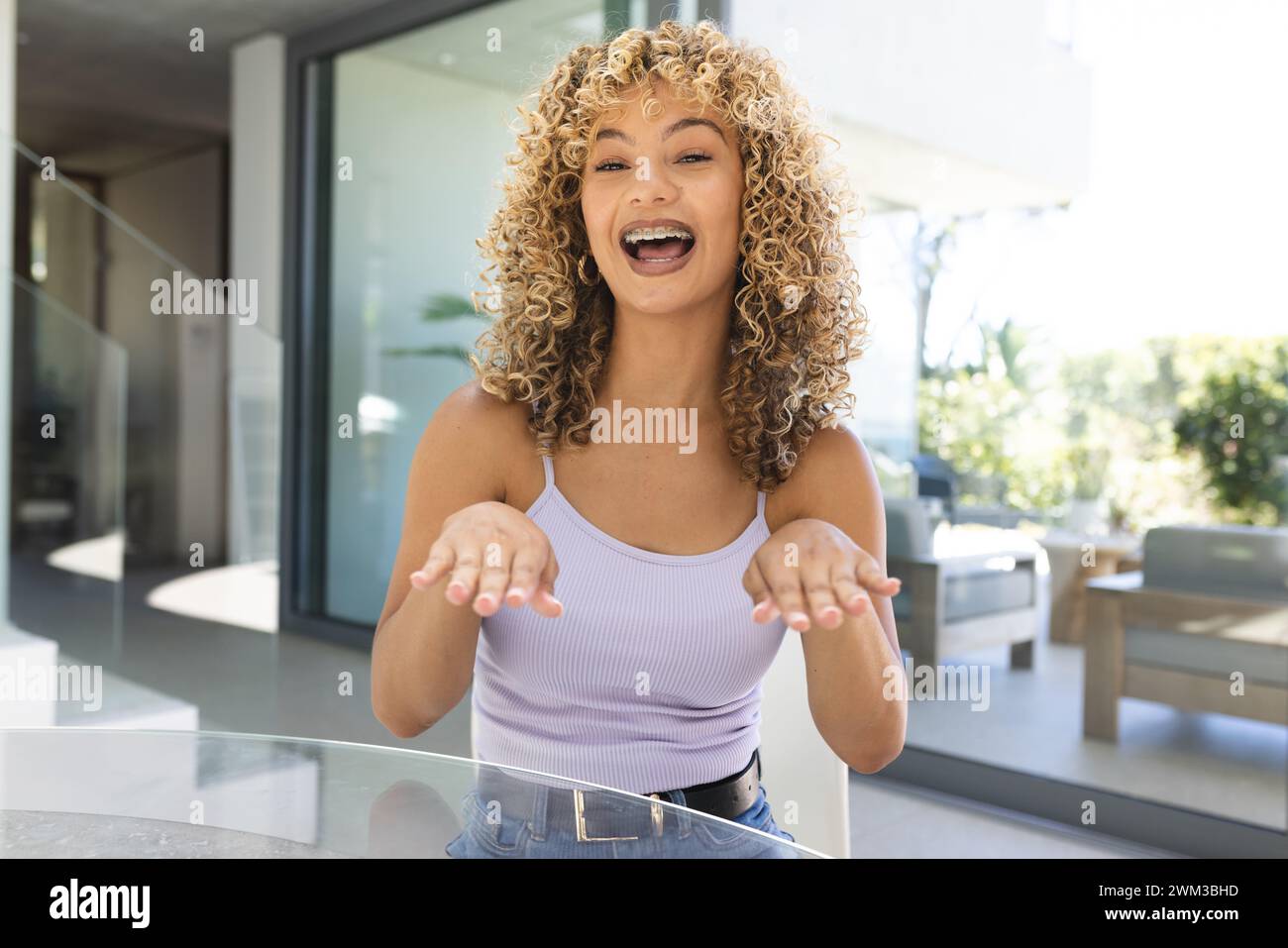 Die junge Frau lacht fröhlich zu Hause bei einem Videoanruf Stockfoto